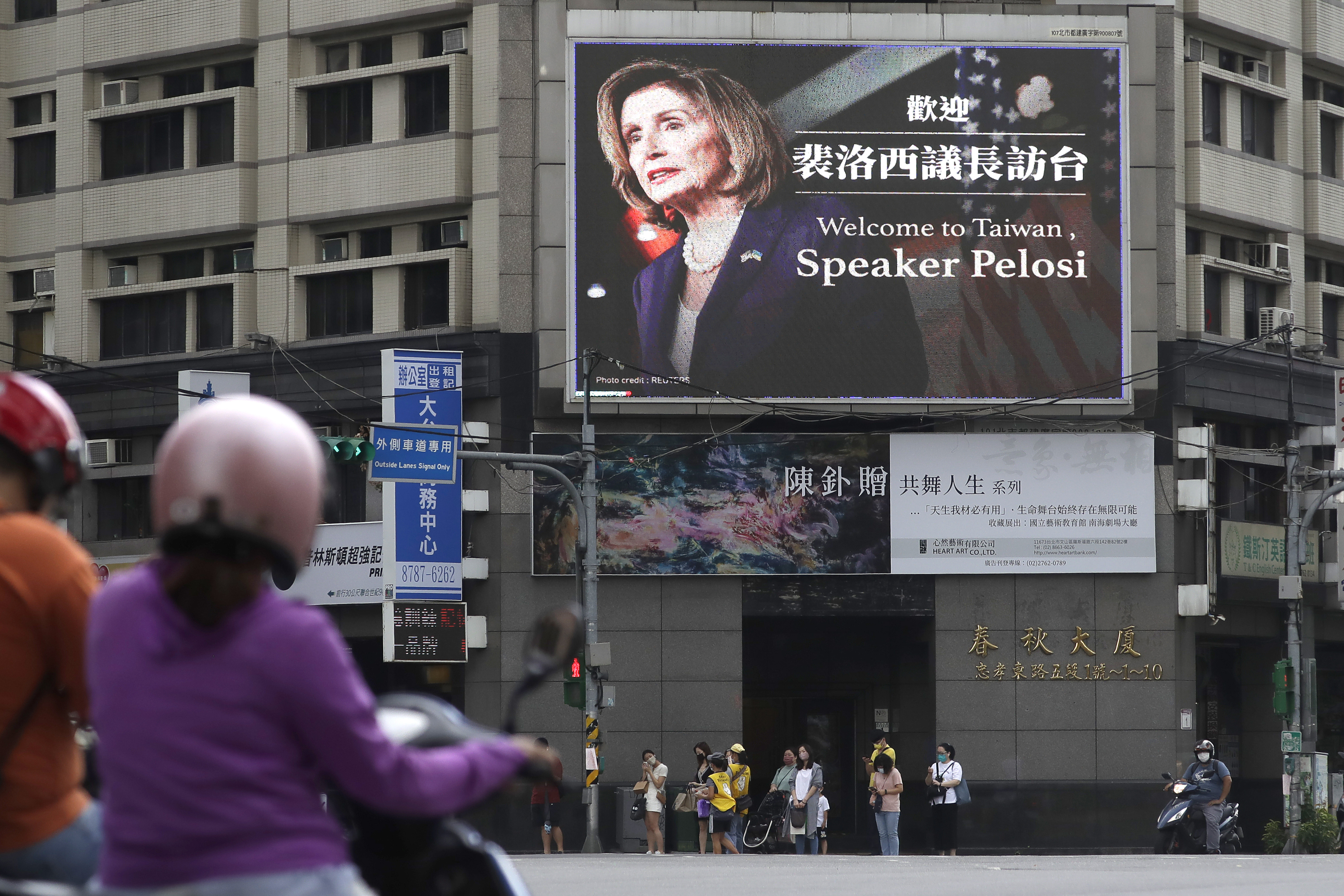 La gente pasa frente a un cartel que da la bienvenida a la presidenta de la Cámara de Representantes de Estados Unidos, Nancy Pelosi, en Taipei. (Foto AP/Chiang Ying-ying)