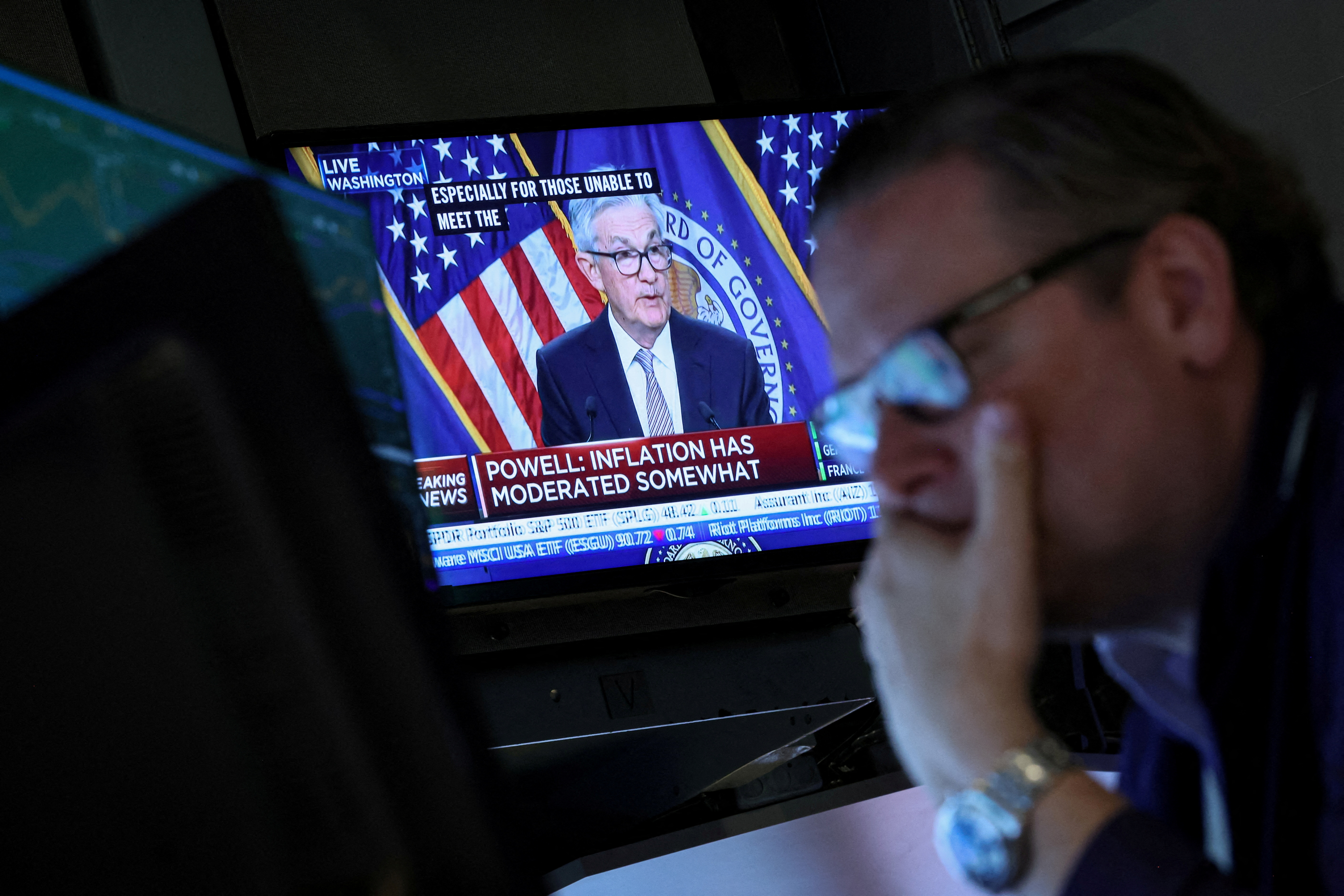 Los operadores reaccionan mientras el presidente de la Reserva Federal, Jerome Powell, pronuncia un discurso en una pantalla, en el parqué de la Bolsa de Nueva York (REUTERS/Brendan McDermid)