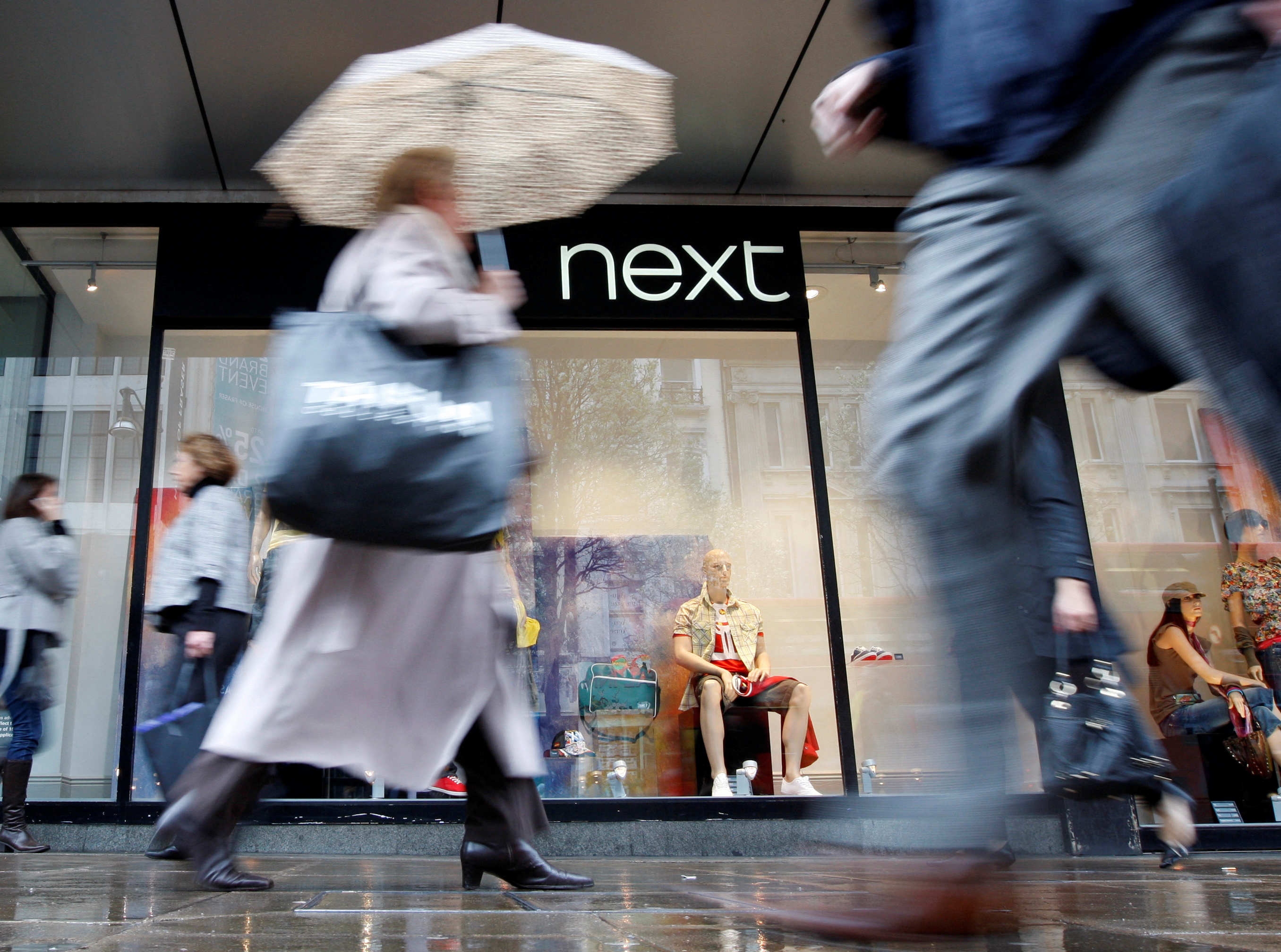 FOTO DE ARCHIVO: Los peatones pasan por delante de una tienda Next en Oxford Street, en Londres. REUTERS/Stephen Hird
