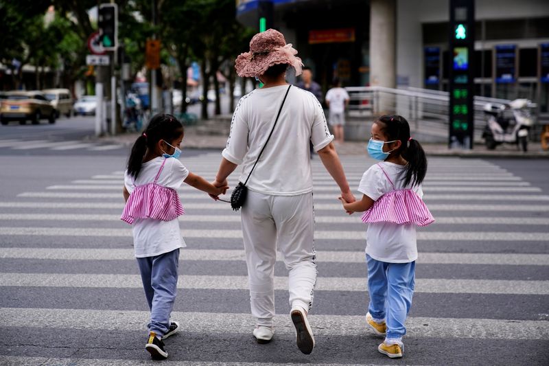 Mujer camina con dos niñas en calle de Shanghái, China, 7 junio 2021.
REUTERS/Aly Song