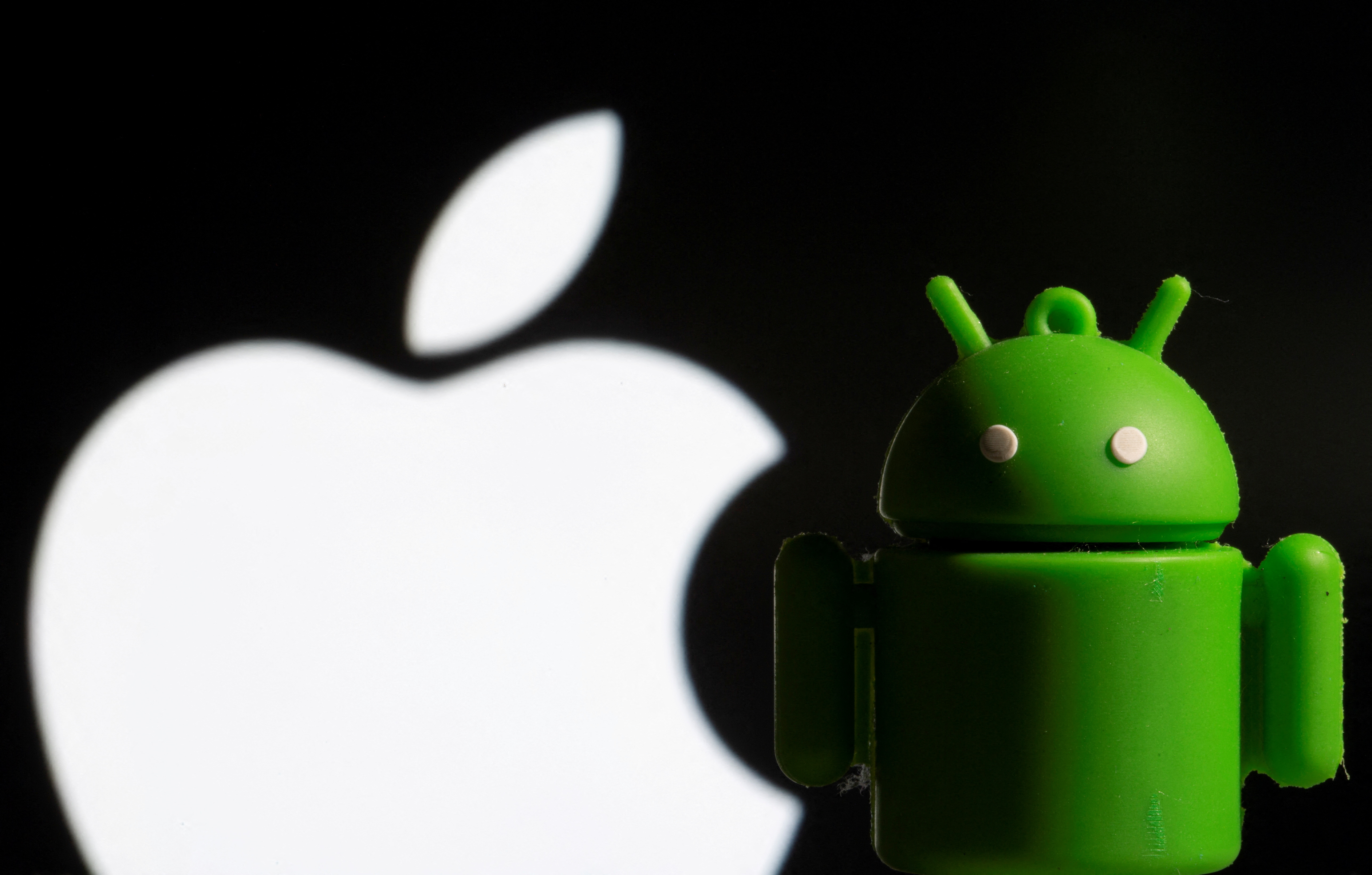 FILE PHOTO: A 3D printed Android mascot Bugdroid is seen in front of the Apple logo in this illustration taken November 3, 2021. REUTERS/Dado Ruvic/Illustration/File Photo