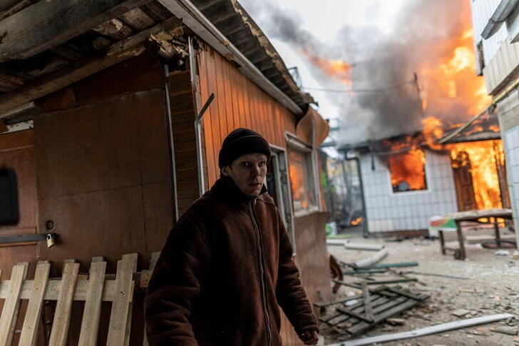 Una persona escapa de una casa en llamas tras un bombardeo ruso contra la localidad de Irpín, cercana a la capital Kiev, Ucrania. 6 marzo 2022. REUTERS/Carlos Barría