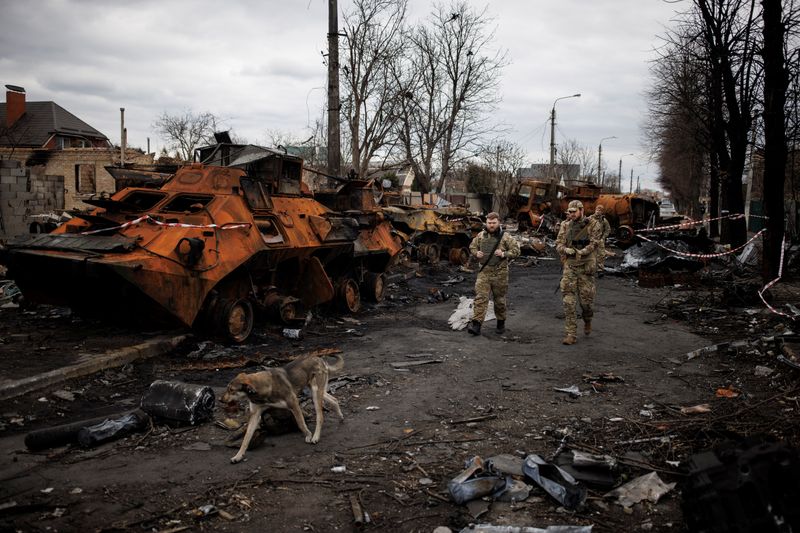 Soldados ucranianos caminan junto a tanques y vehículos blindados rusos destruidos en Bucha (REUTERS/Alkis Konstantinidis)