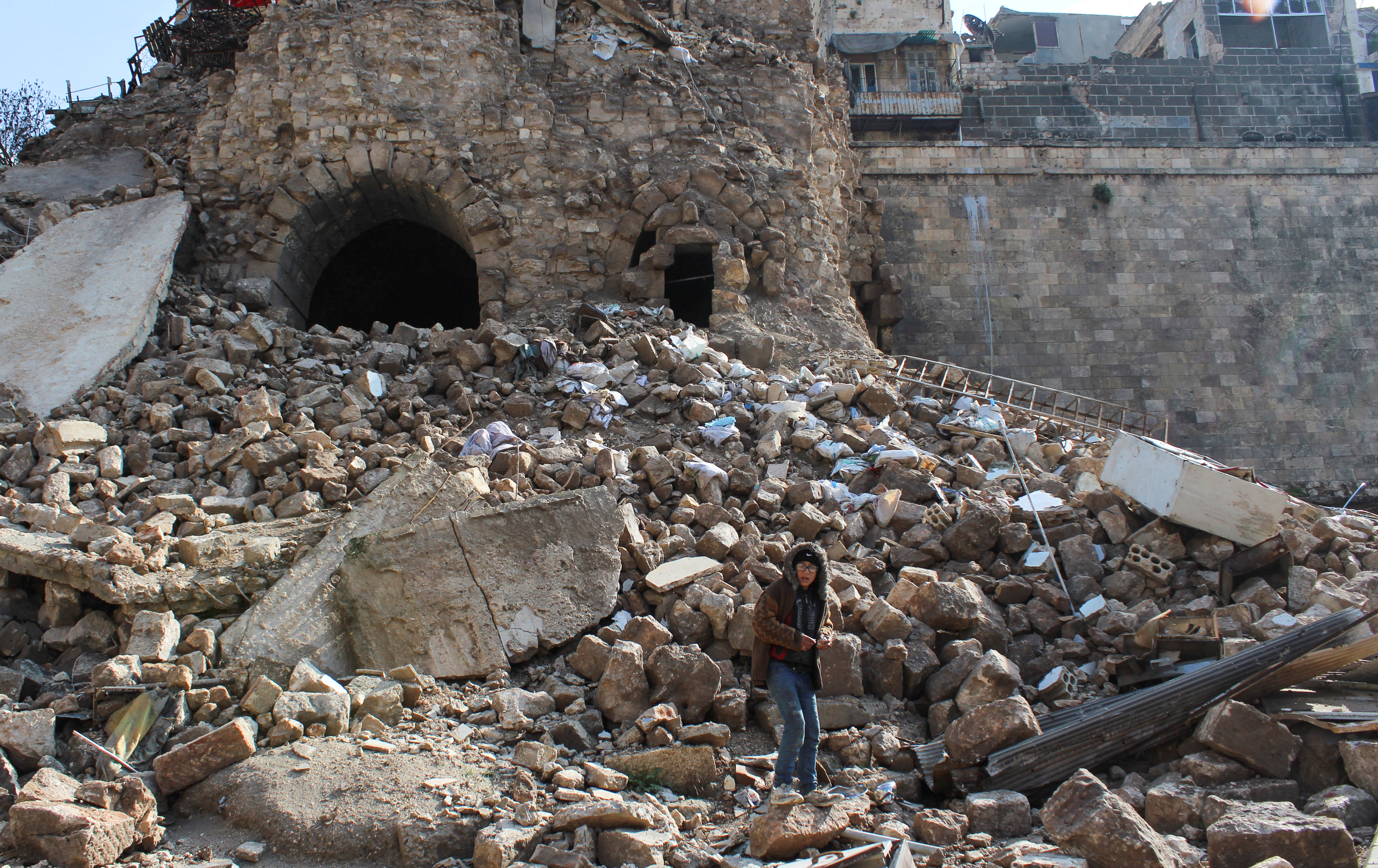 Un niño sobre los escombros tras el terremoto cerca de la antigua ciudadela de Alepo, en el casco antiguo de Alepo, Siria, 7 de febrero de 2023. REUTERS/Firas Makdesi
