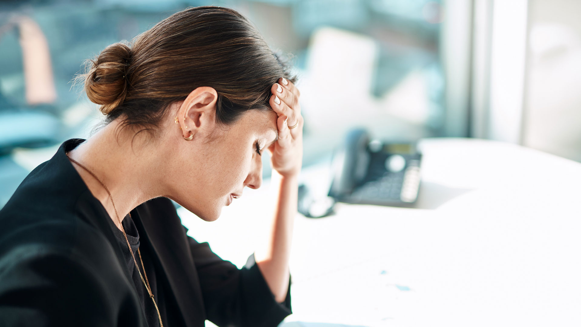 Shot of a businesswoman experiencing stress while working in a modern office. (Getty)
