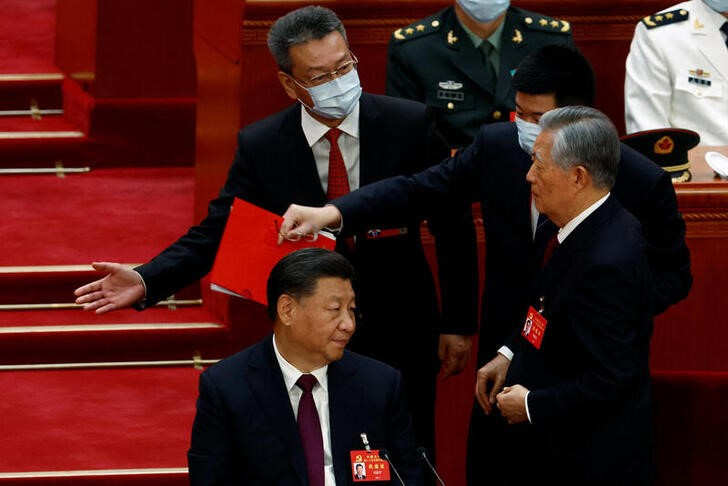 El ex presidente chino Hu Jintao es sacado de su lugar por dos escoltas junto al jefe del régimen chino Xi Jinping durante la ceremonia de clausura del 20 Congreso Nacional del Partido Comunista de China