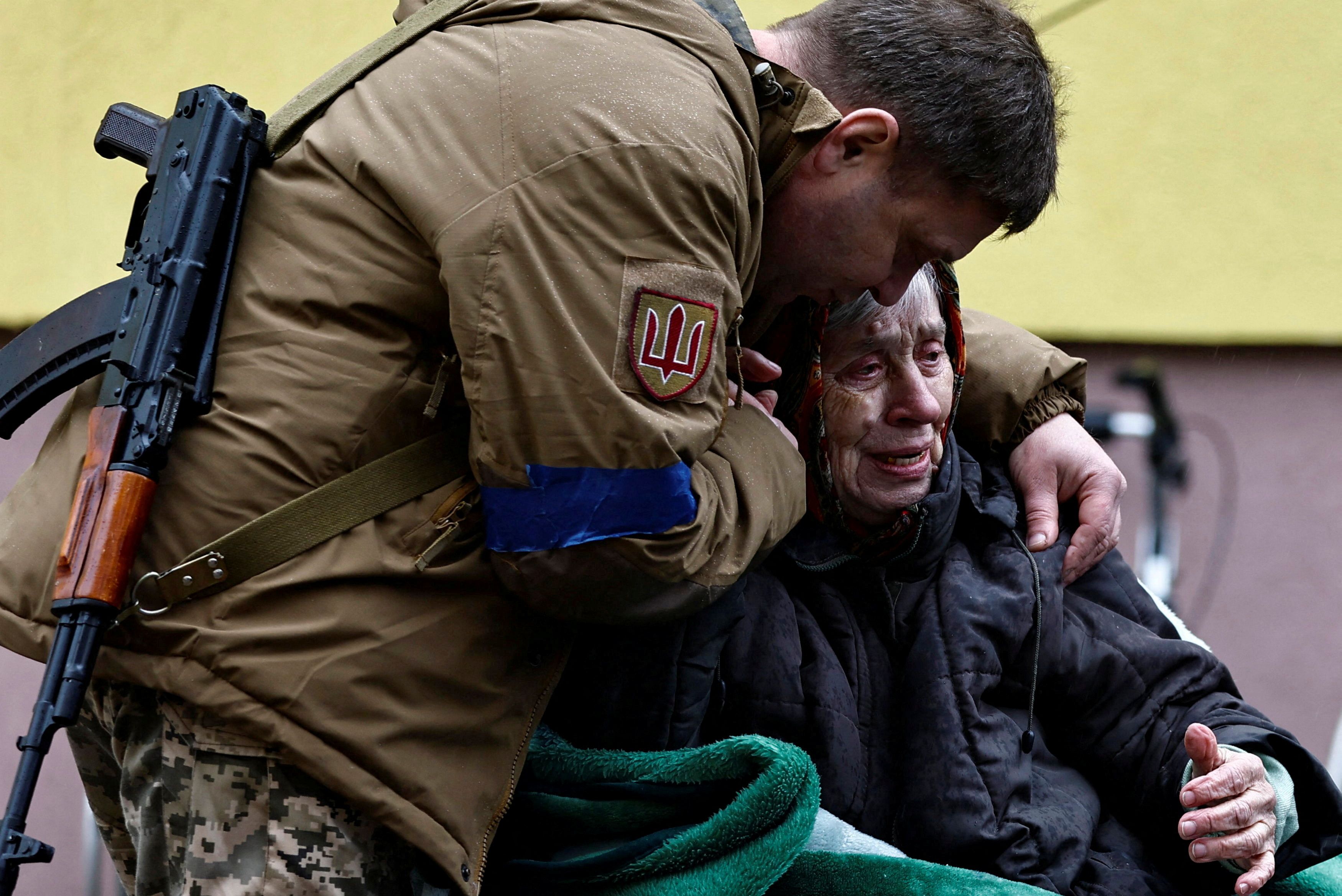 Un militar ucraniano abraza a su madre Larysa Kolesnyk, de 82 años, después de que fuera evacuada de la ciudad de Irpin, mientras continúa el ataque de Rusia a Ucrania, en las afueras de Kiev, Ucrania, 30 de marzo de 2022. (REUTERS/Zohra Bensemra)
