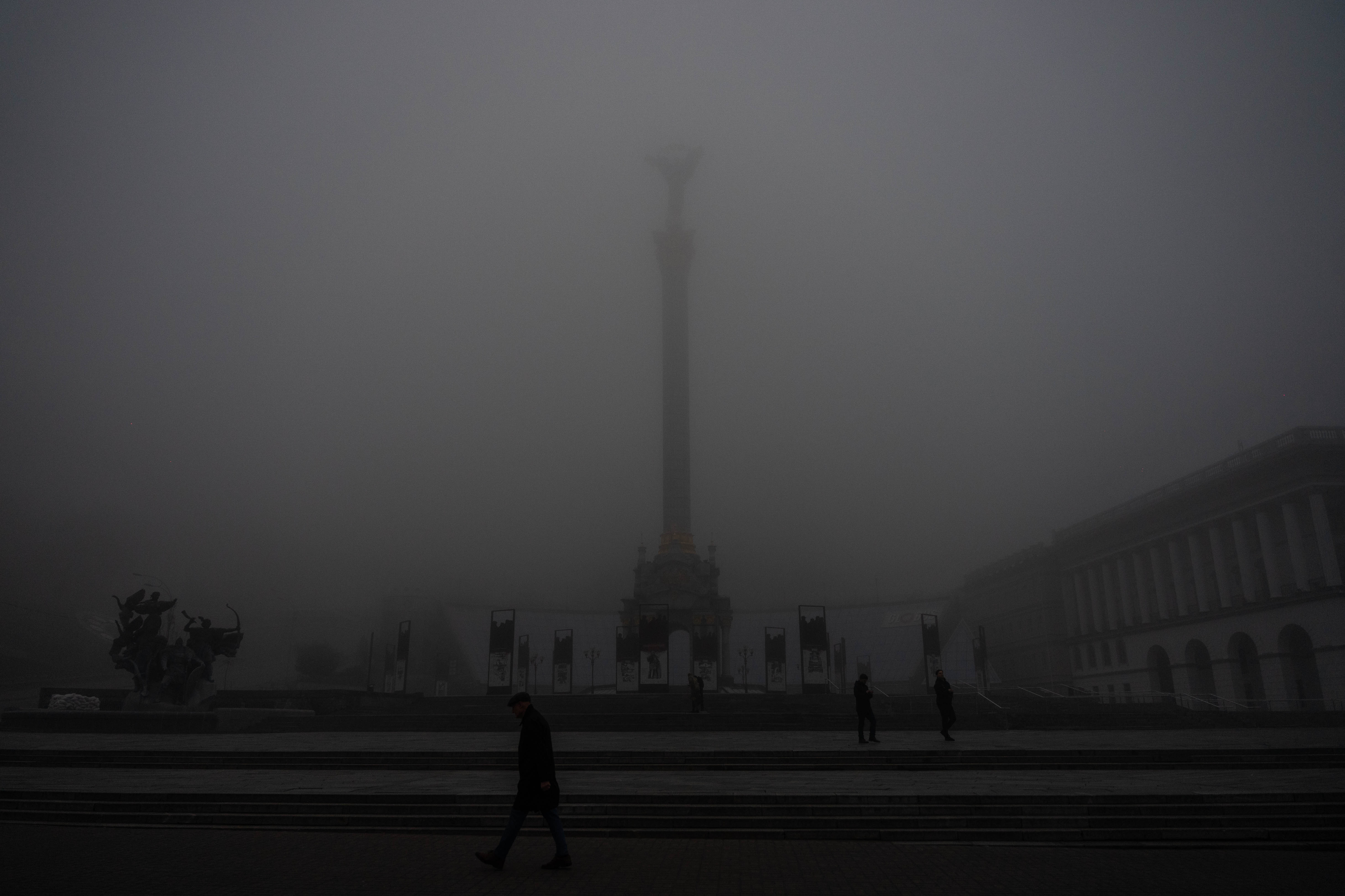 Entre nieblas y barricadas, vecinos de Kyiv caminan por la emblematica plaza Maidan.