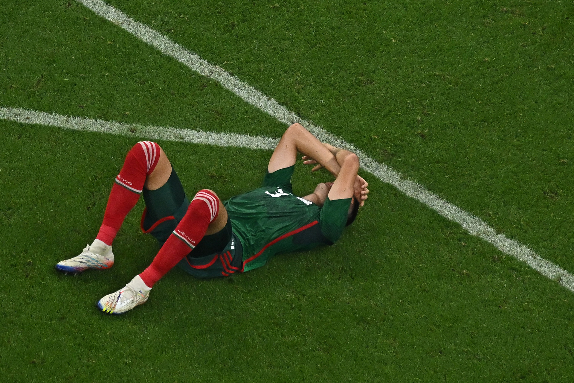 Mexico's defender #03 Cesar Montes lies on the ground at the end of the Qatar 2022 World Cup Group C football match between Saudi Arabia and Mexico at the Lusail Stadium in Lusail, north of Doha on November 30, 2022. (Photo by MANAN VATSYAYANA / AFP)