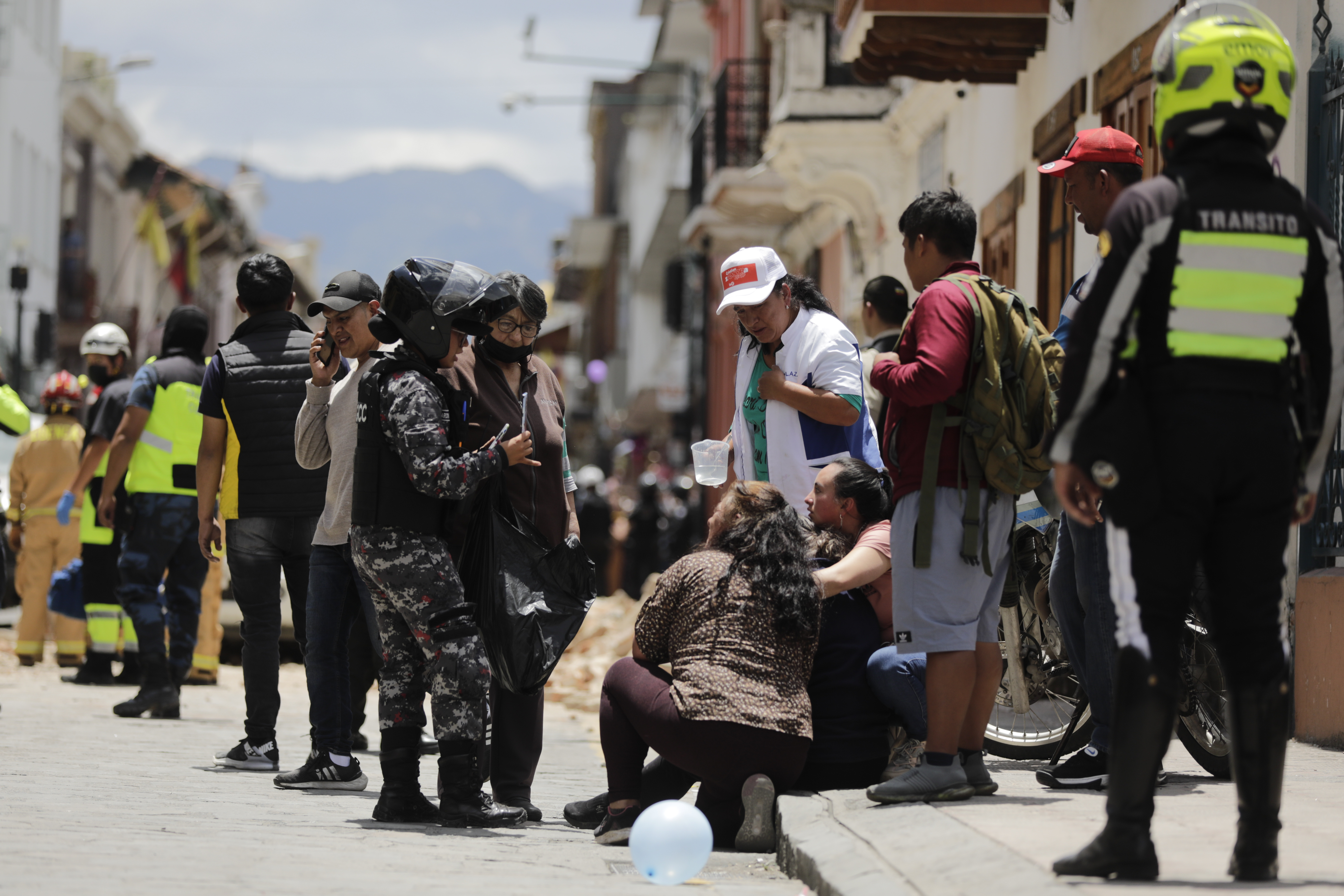 Police have spoken to people near the site where a car was crushed by rubble after a strong earthquake struck Cuenca, Ecuador on Saturday, March 18, 2023. Register 50 Milias Al Sur de Guayaquil in Guayaquil.  (Photo AP/Xavier Caivinagua)
