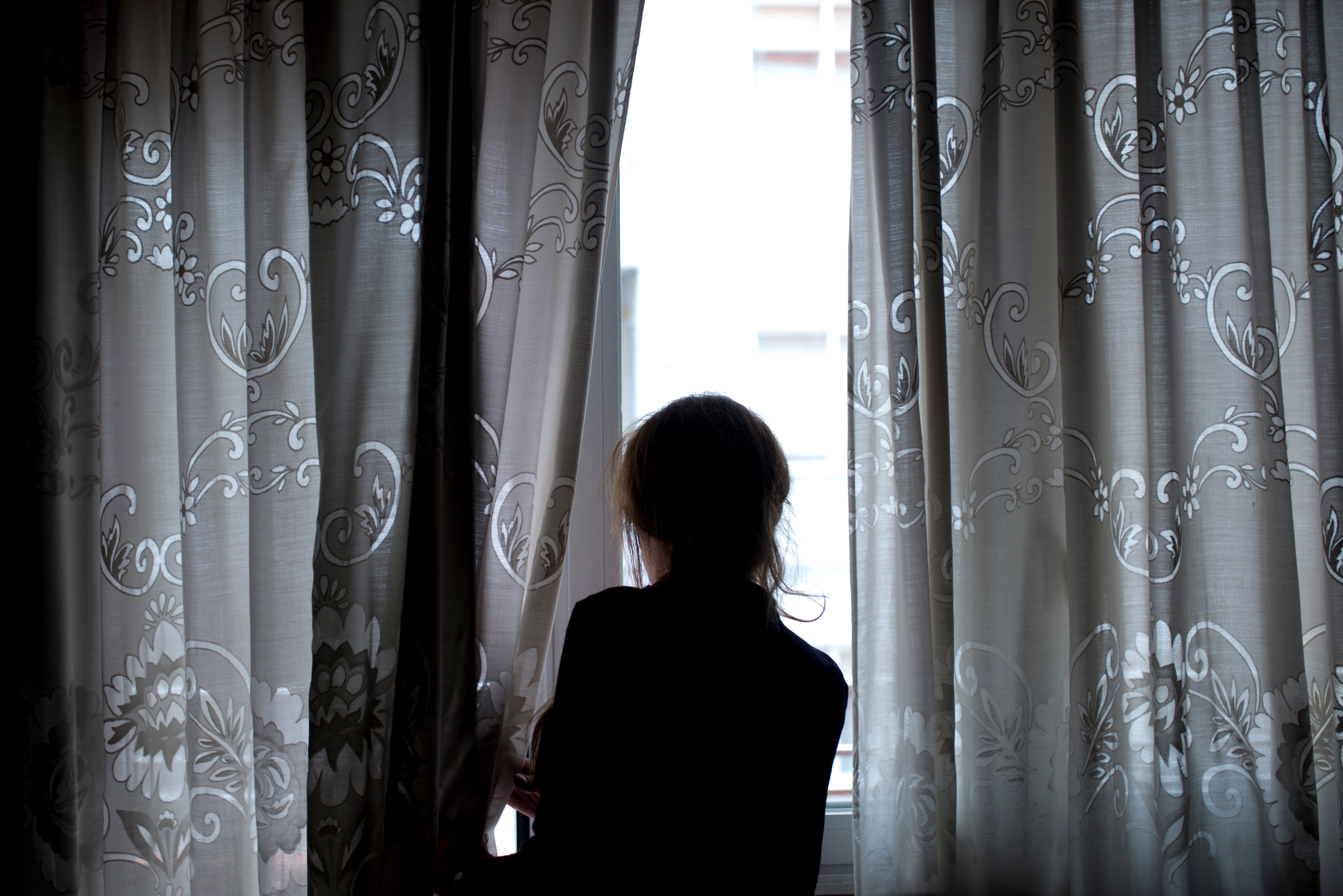 Una mujer observa a través de la ventana de su vivienda, en foto de archivo. EFE/Brais Lorenzo
