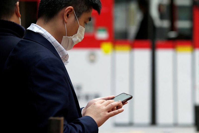 Un hombre mira su teléfono móvil en Hong Kong, China 10 de febrero de 2020. REUTERS/Tyrone Siu/Archivo