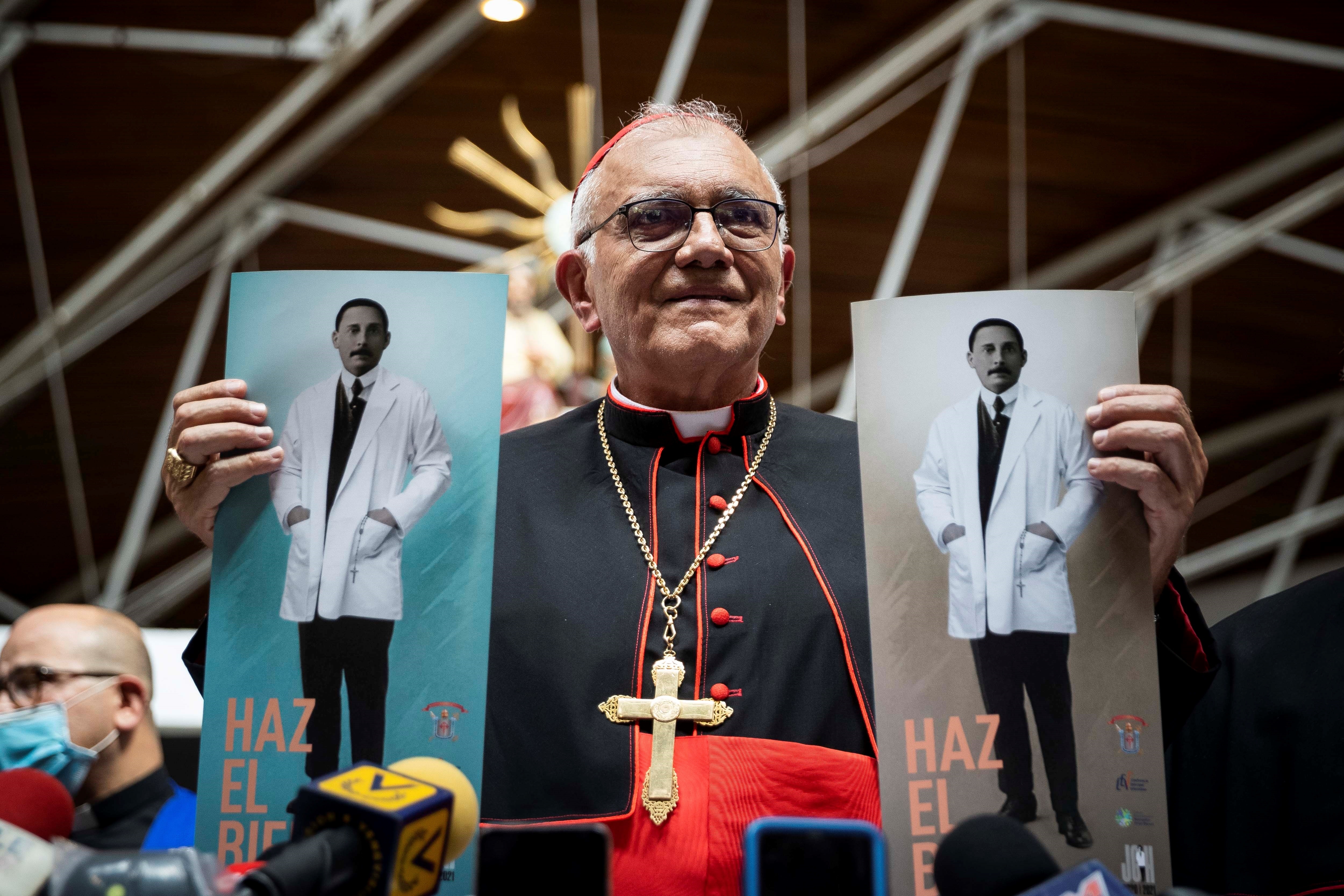 En la imagen, el cardenal Baltazar Porras sostiene afiches de José Gregorio Hernández en la Iglesia Parroquia Inmaculado Corazón de María de Caracas (EFE)
