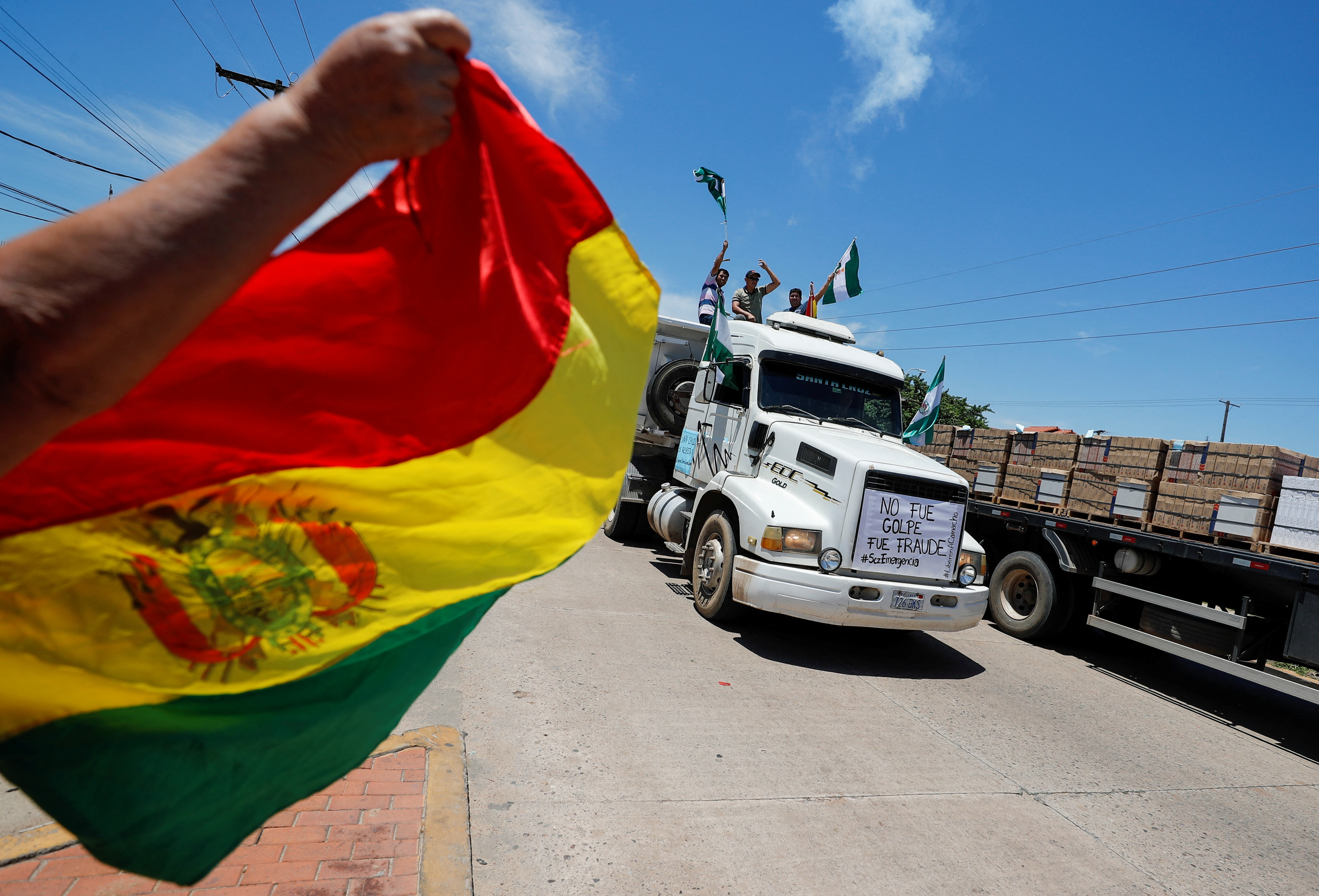 Manifestantes en lo alto de un camión ondean banderas durante una protesta tras la detención del gobernador de Santa Cruz y líder opositor Luis Fernando Camacho (REUTERS/Agustin Marcarian)