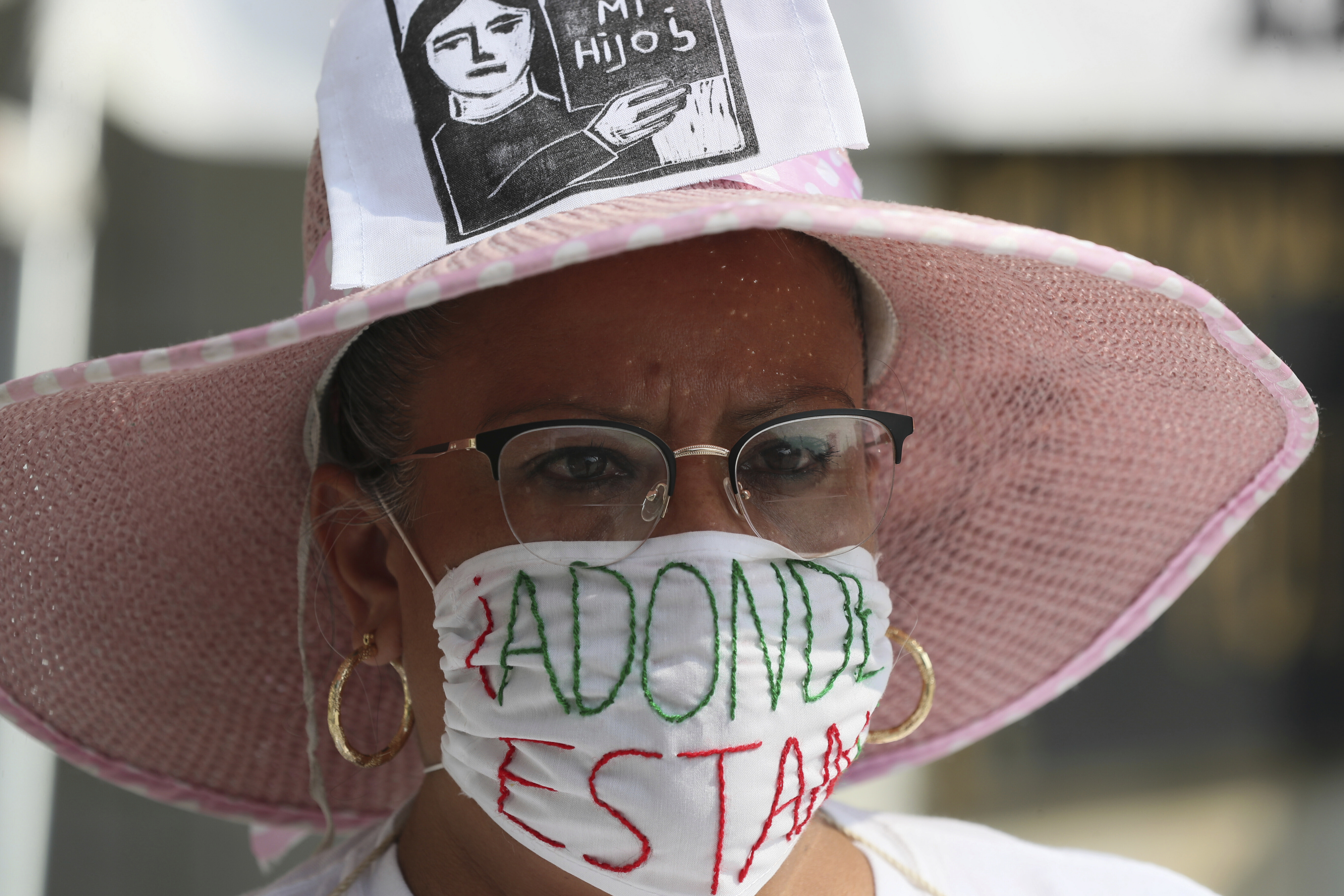 Un manifestante con una máscara contra la propagación del nuevo coronavirus tiene un mensaje que dice