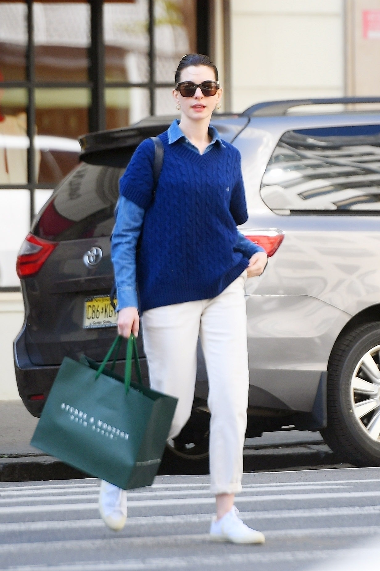 Día de compras. Anne Hathaway recorrió las tiendas más exclusivas de la Quinta Avenida en Nueva York. La actriz lució un pantalón blanco, camisa azul y sweater del mismo color. Llevó su pelo recogido y lentes de sol (Fotos: The Grosby Group)