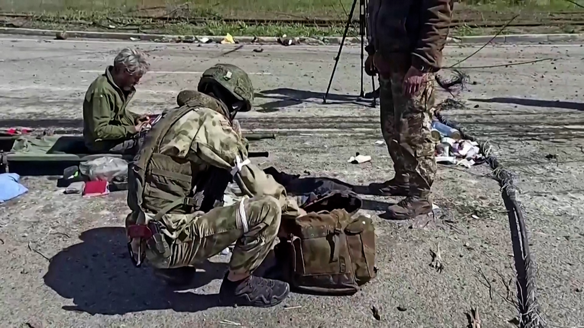 The footage shows how soldiers who left the metallurgical plant, some of them women, leave the Azovstal territory with their mats and suitcases following and stand in a single line to be searched by Russian soldiers.