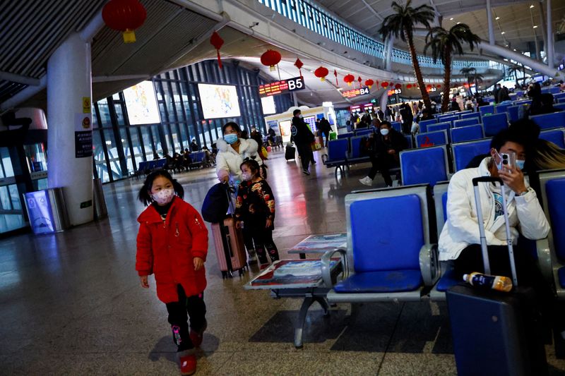 FOTO DE ARCHIVO. Un niño camina mientras la gente espera con sus maletas en una estación de tren, en medio del brote de la enfermedad por coronavirus (COVID-19), en Wuhan, provincia de Hubei, China. 1 de enero de 2023. REUTERS/Tingshu Wang
