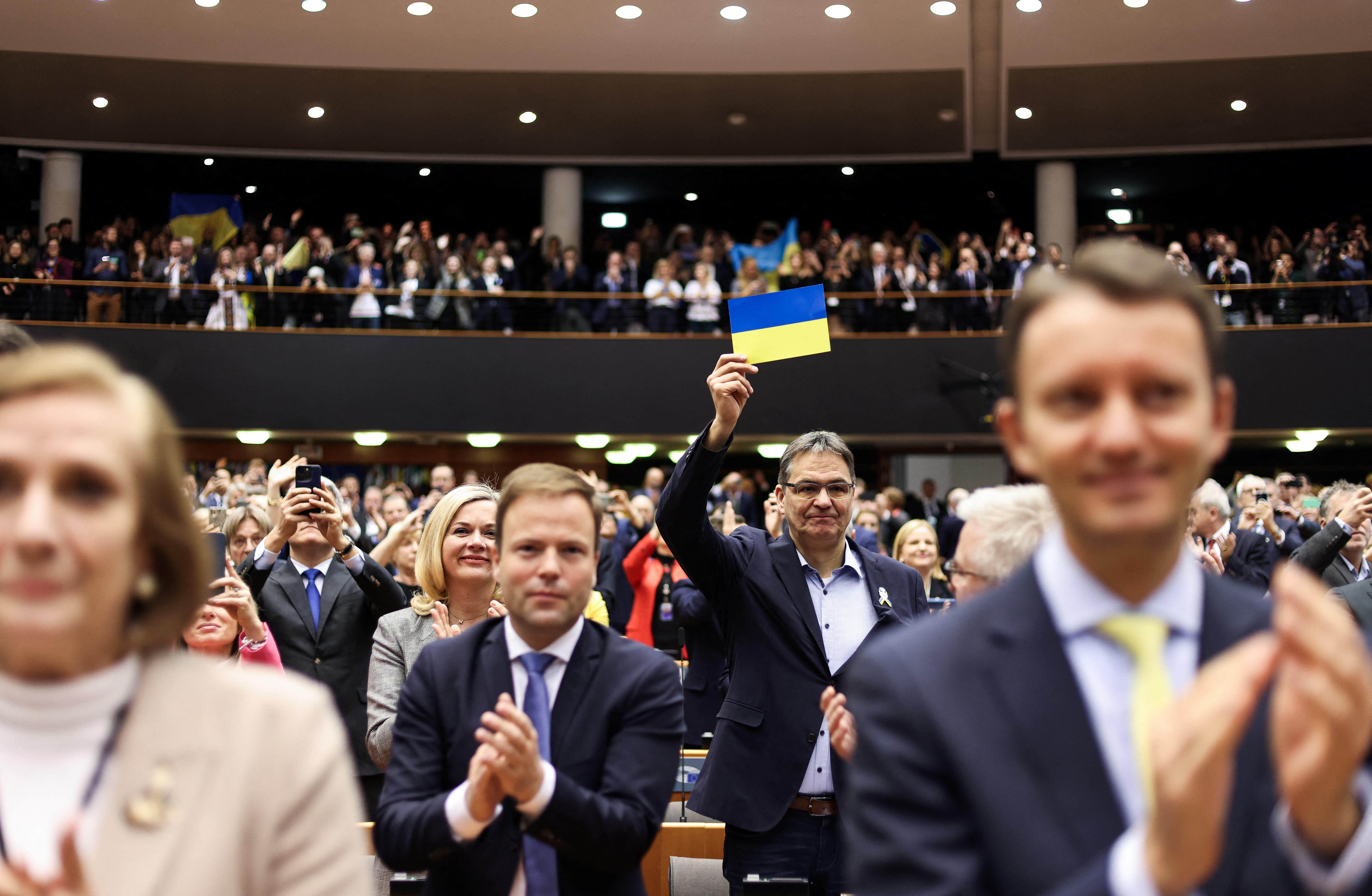 Un eurodiputado con la bandera ucraniana. Zelensky aseguró que la perspectiva de que su país se una a la UE los motiva a mantenerse fuertes y mantener el rumbo. (Kenzo TRIBOUILLARD / AFP)