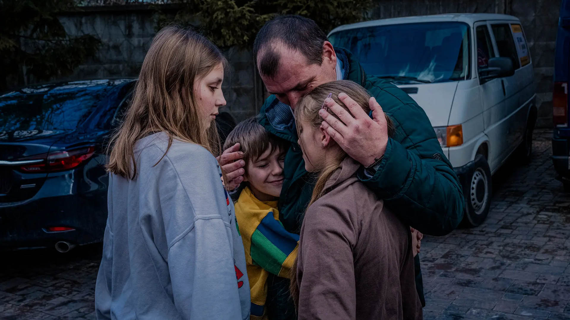 Denys Zaporozhchenko is reunited with his children, Dayana, Yana and Nikita, in kyiv, Ukraine, on March 22, 2023. (Daniel Berehulak/The New York Times)
