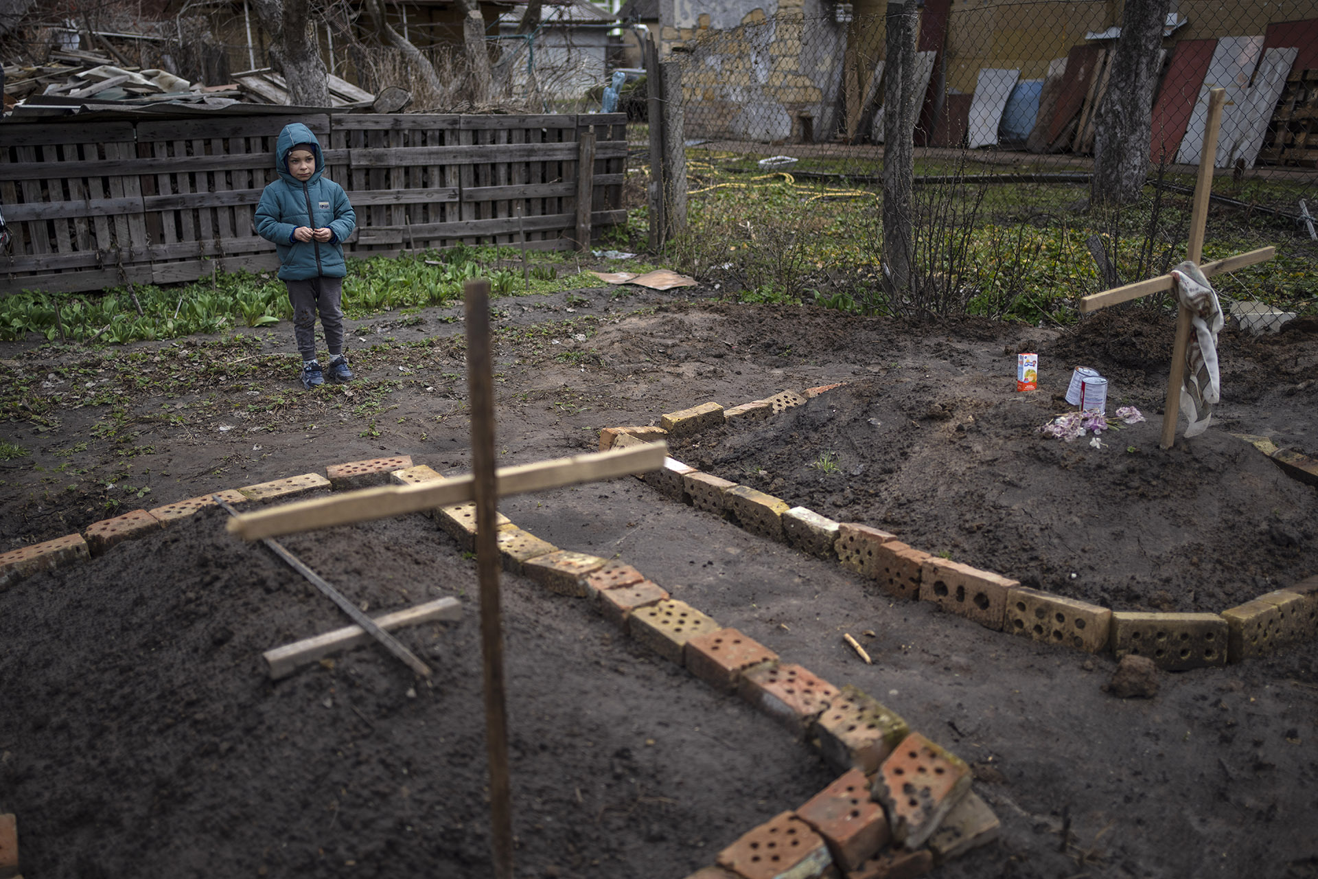 Vlad de cara a la tumba de su madre y la de otro vecino en el patio de su kasa.  Por el fuego cruzado de los enfrentamientos, no pudieron velarlos el cementmentio (AP Photo / Rodrigo Abd)