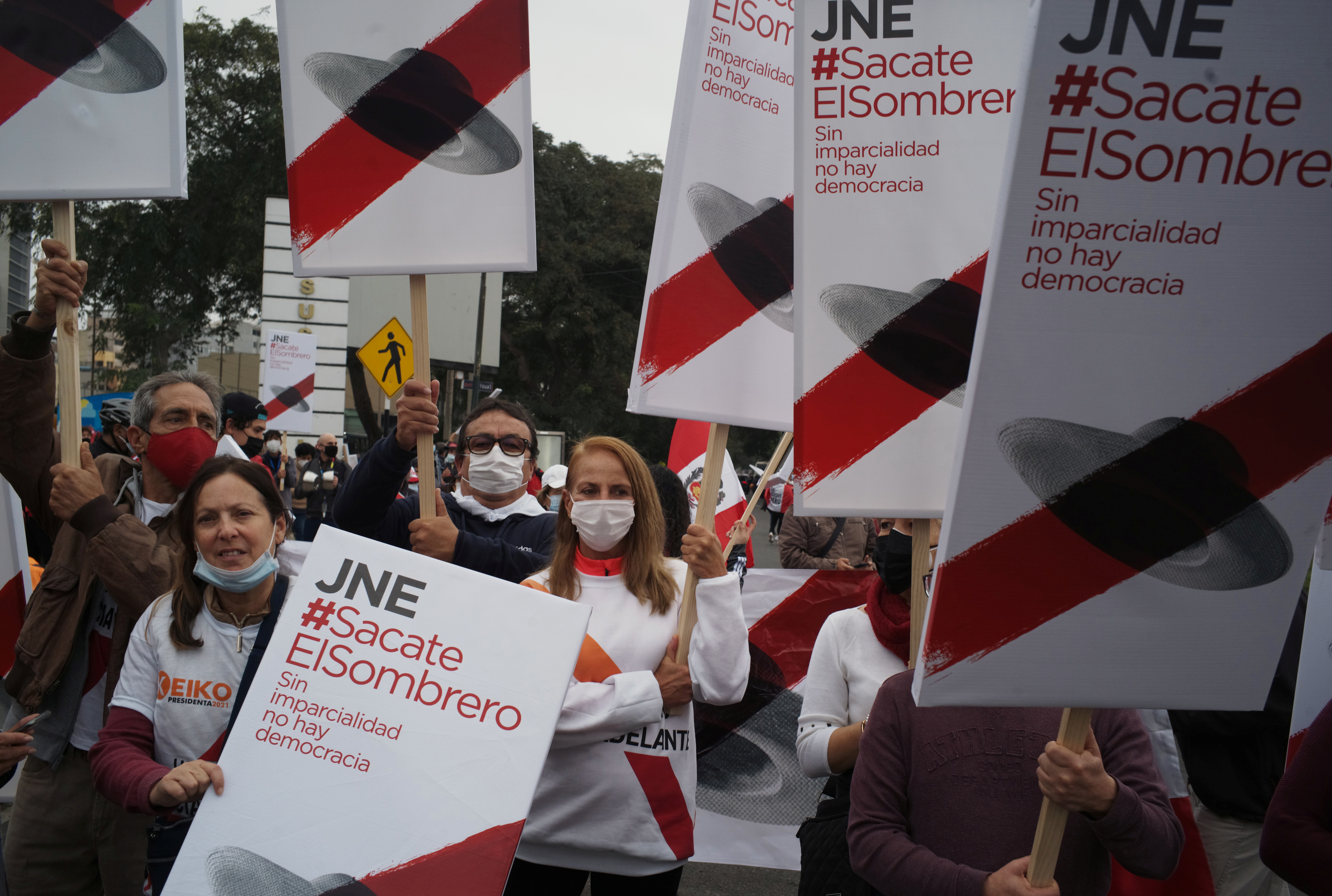 Simpatizantes de la candidata presidencial de Perú Keiko Fujimori sostienen carteles que dicen "Jurado Nacional de Elección (JNE) #Takeyourhatoff, sin imparcialidad no hay democracia" durante una manifestación en Lima, Perú, el 12 de junio de 2021. REUTERS / Alessandro Cinque
