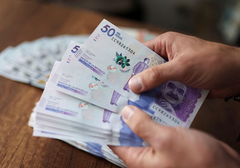 Foto de archivo. Un empleado cuenta billetes de pesos colombianos en una casa de cambio en Bogotá, Colombia, 11 de julio, 2022. REUTERS/Luisa González