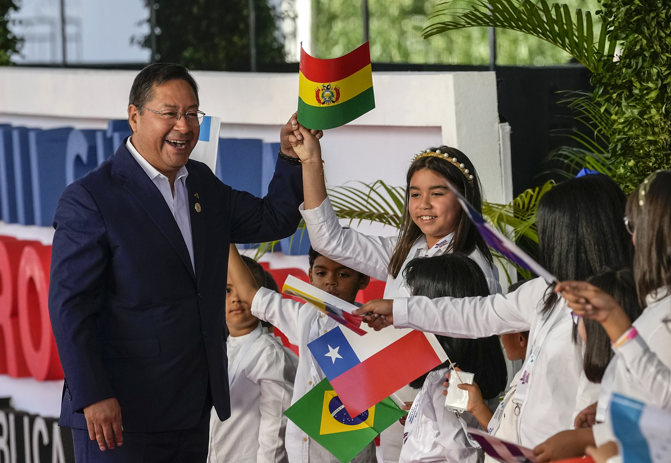 El presidente de Bolivia, Luis Arce, saluda a los niños a su llegada a la sesión de la 28ª Cumbre Iberoamericana, en Santo Domingo, República Dominicana, el sábado 25 de marzo de 2022. (Foto AP/Ariana Cubillos)