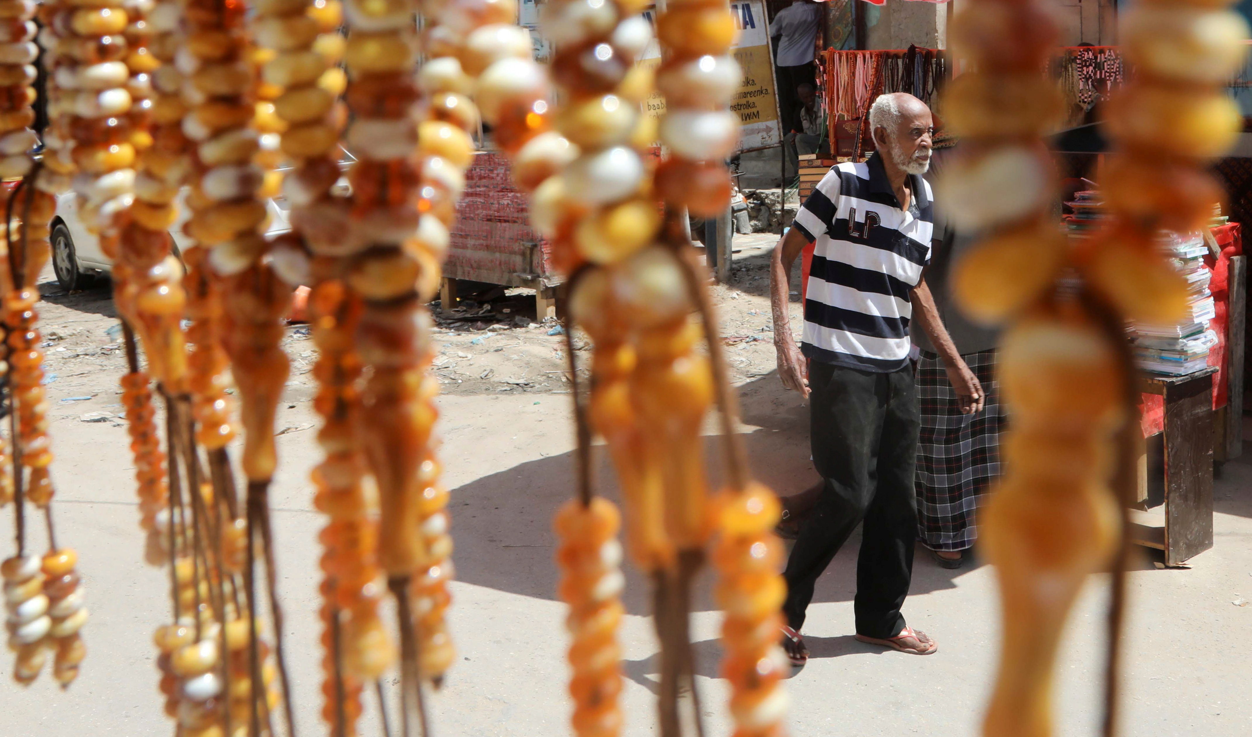 A man walks past a jewellery made from recycled camel bones, displayed at the Hamarweyne market, in Mogadishu, Somalia October 25, 2021. Picture taken October 25, 2021. REUTERS/Feisal Omar