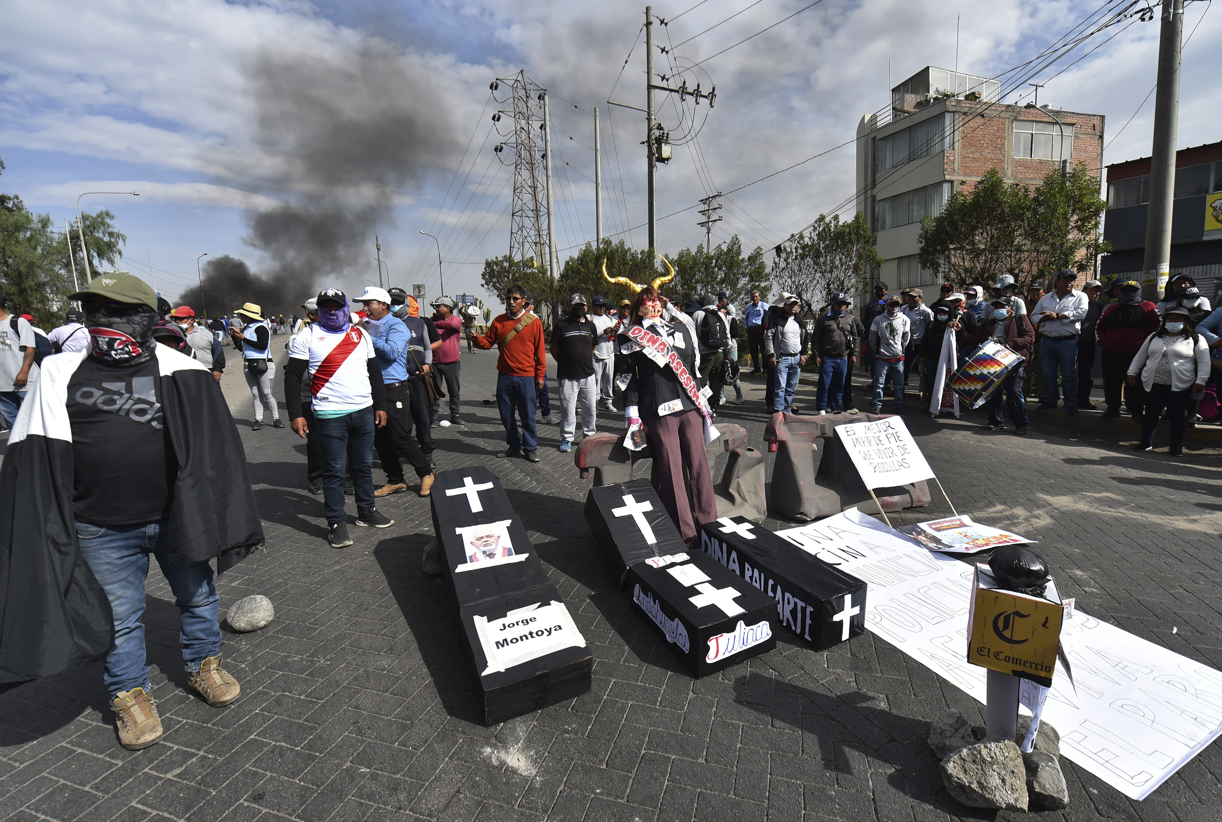 Manifestantes bloquean una carretera con réplicas de ataúdes que llevan los nombres de la presidenta peruana Dina Boluarte y congresistas en Arequipa, Perú, el jueves 19 de enero de 2023. (AP Foto/José Sotomayor)