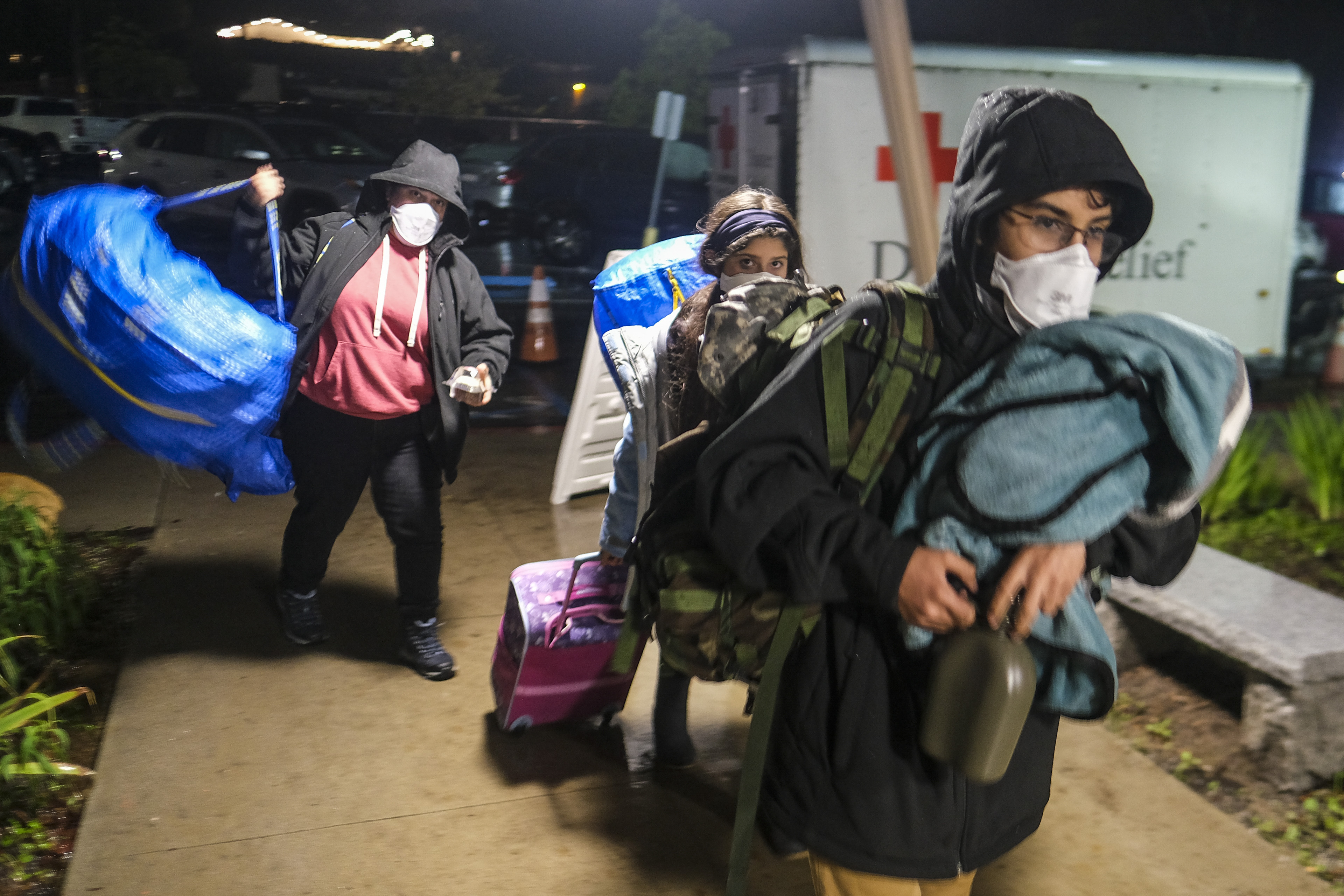 Gente carga sus pertenencias a su llegada a un centro de evacuación en Santa Bárbara, California. (AP Foto/Ringo H.W. Chiu)