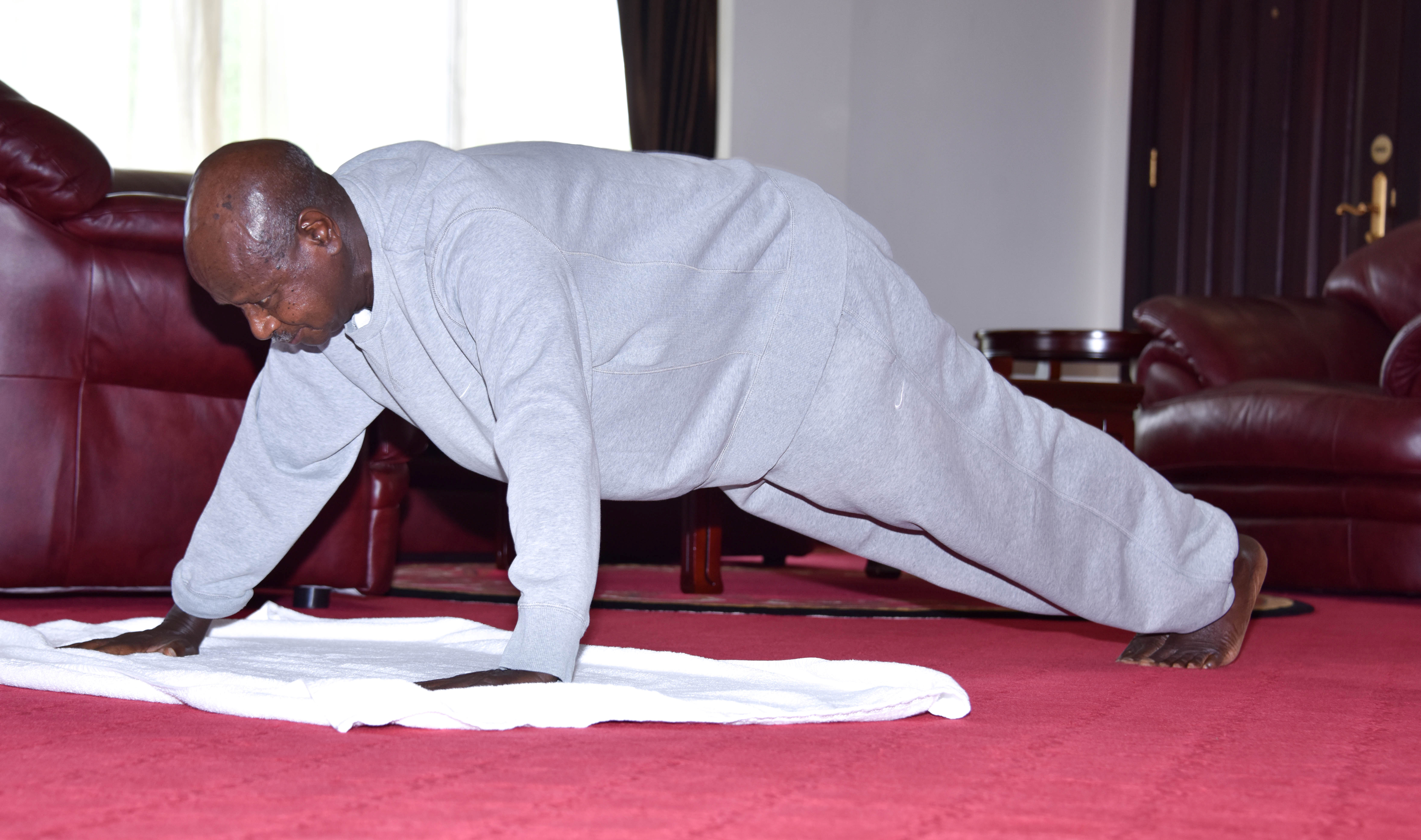 Museveni hace flexiones en la Casa del Estado, en Entebbe, Uganda, el 9 de abril de 2020 (Unidad de Prensa Presidencial / Entrega a través de REUTERS)