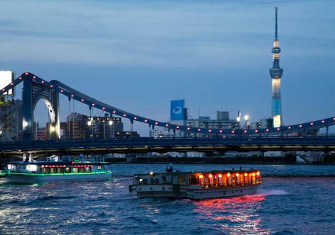 TOKYO, JAPAN - JUNE 11:  Yakatabune traditional low barge style boats sail on the Sumida River as the Tokyo Skytree stands illuminated at dusk on June 11, 2016 in Tokyo, Japan. About 35 companies operate over 100 yakatabune boats in Tokyo offering services such as dinner or karaoke inside the boats while cruising in Tokyo's bay area, according to the Tokyo Yakatabune Association.  (Photo by Tomohiro Ohsumi/Getty Images)