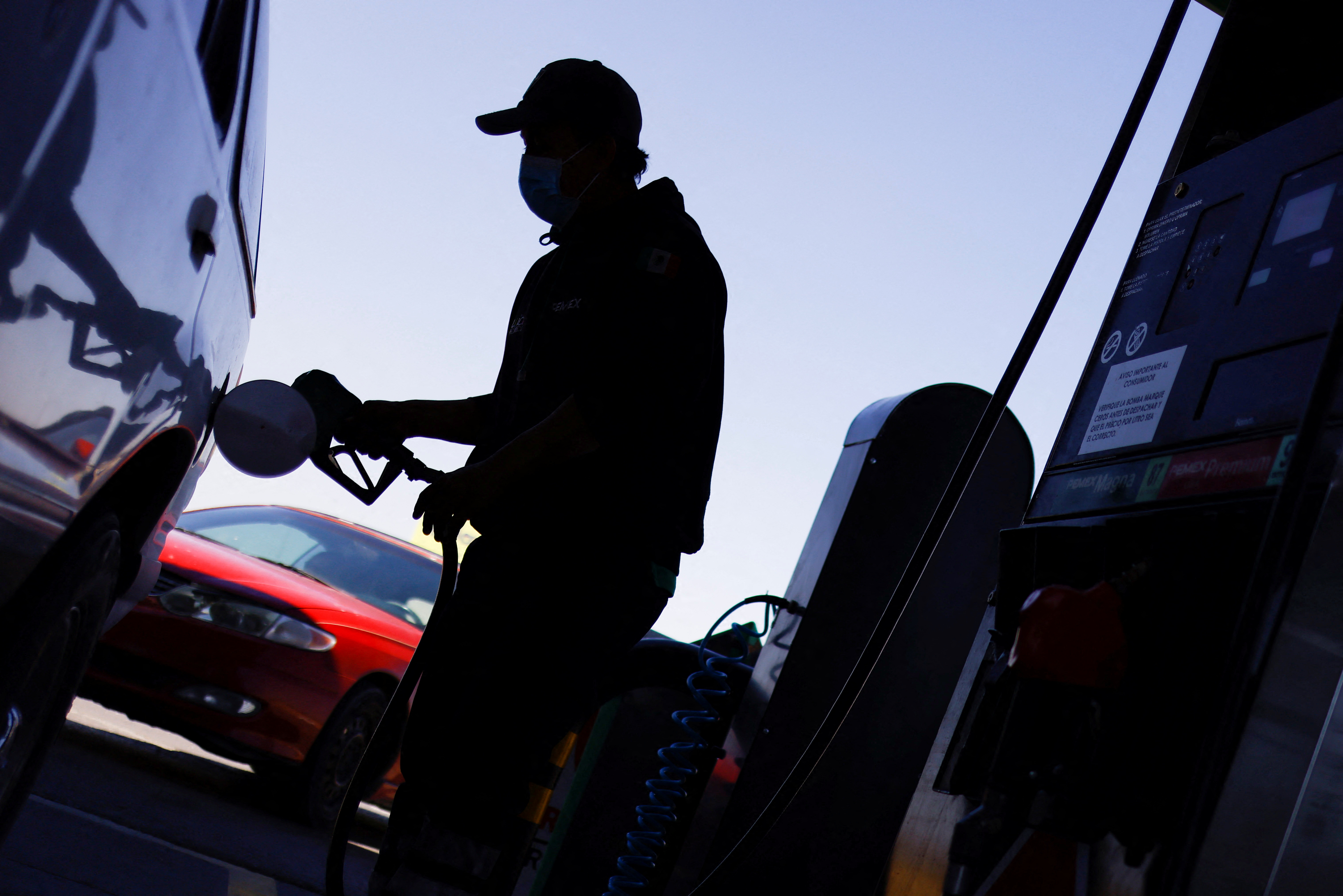 A worker fills a car with gasoline at a service station after Mexico suspended a week of gasoline subsidy along the U.S. border, in Ciudad Juarez, Mexico April 2, 2022. REUTERS/Jose Luis Gonzalez