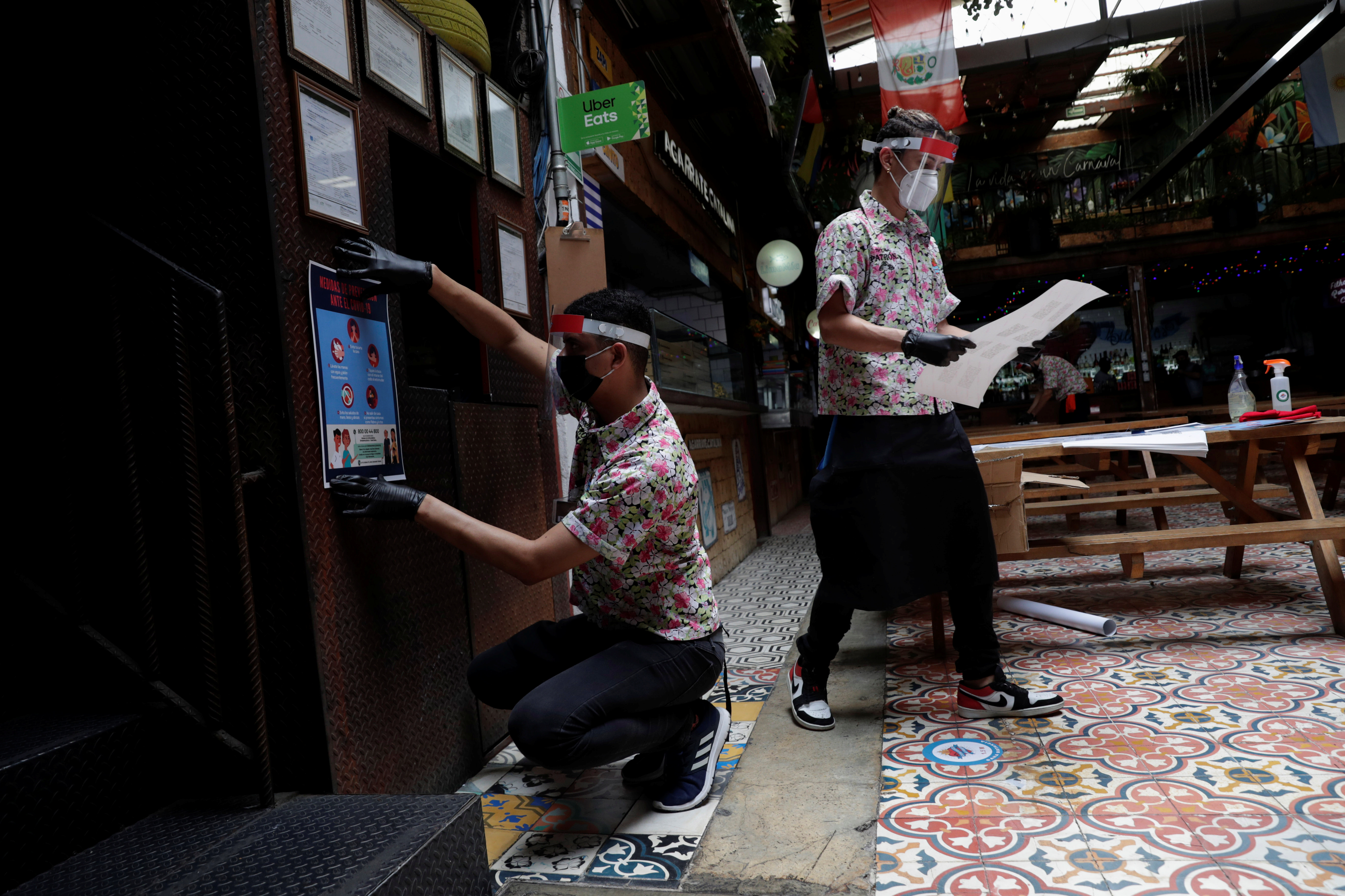 Un camarero coloca una señal de distancia social mientras espera que el restaurante Comedor de los Milagros vuelva a abrir, durante el inicio de la reapertura gradual de las actividades comerciales en la ciudad, a medida que continúa el brote de la enfermedad por coronavirus (COVID-19), en la Ciudad de México, México. Junio 30, 2020. (Foto: REUTERS / Henry Romero)