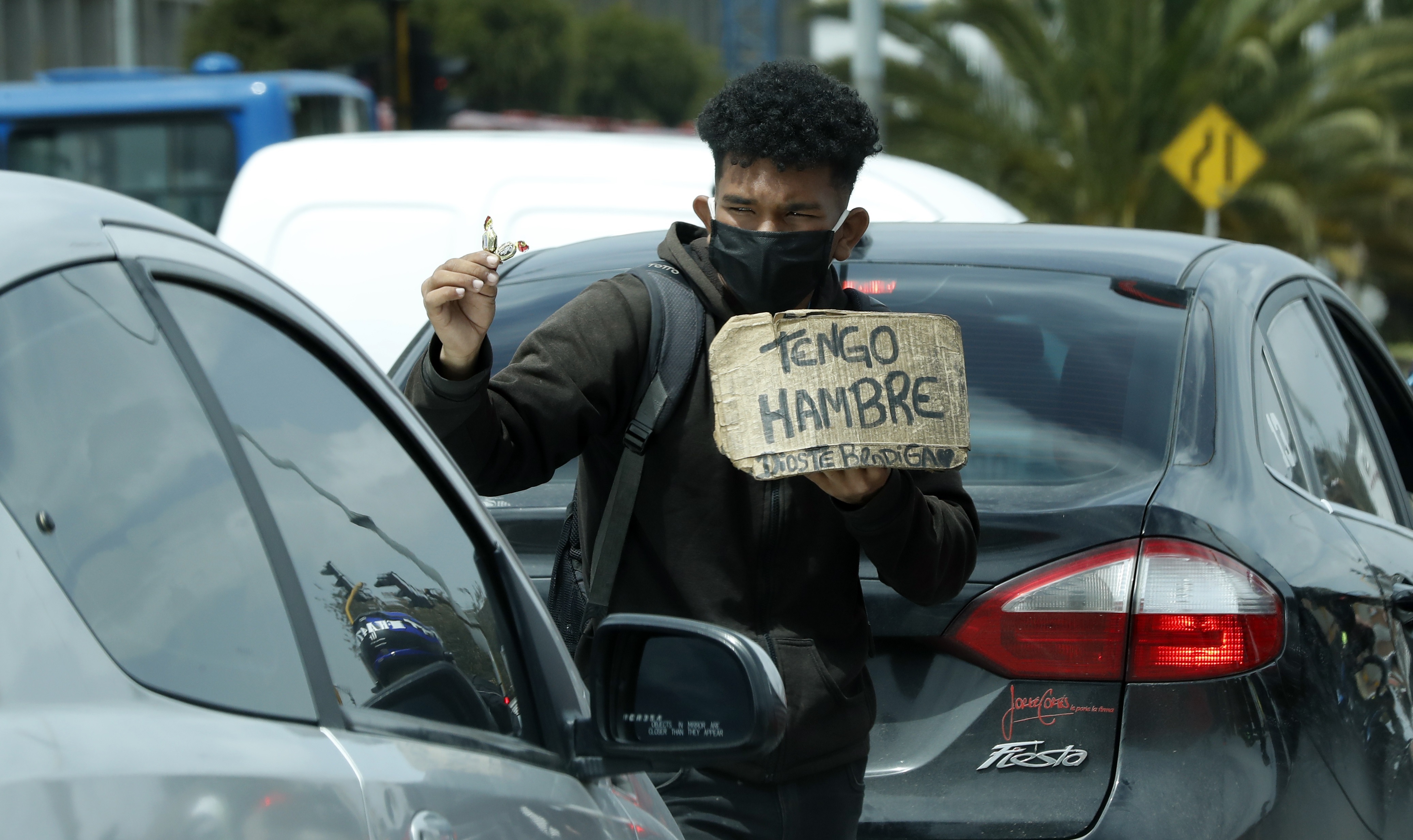 Un hombre vende dulces y pide ayuda en un semáforo de Bogotá. EFE/ Mauricio Dueñas Castañeda/Archivo
