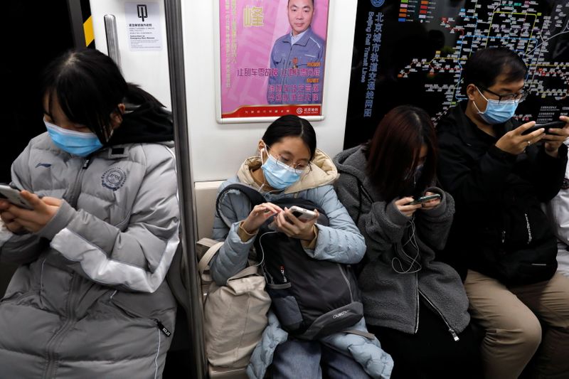 Personas en el metro mirando sus teléfonos, Beijing, China, 25 diciembre 2020. REUTERS/Tingshu Wang/Archivo