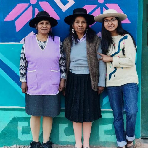 Celeste junto a dos maestras tejedoras, quien está a su lado es su madre, Lucrecia Cruz, en la casita de colores ubicada en Huacalera, provincia de Jujuy, a menos de dos kilómetros del Trópico de Capricornio