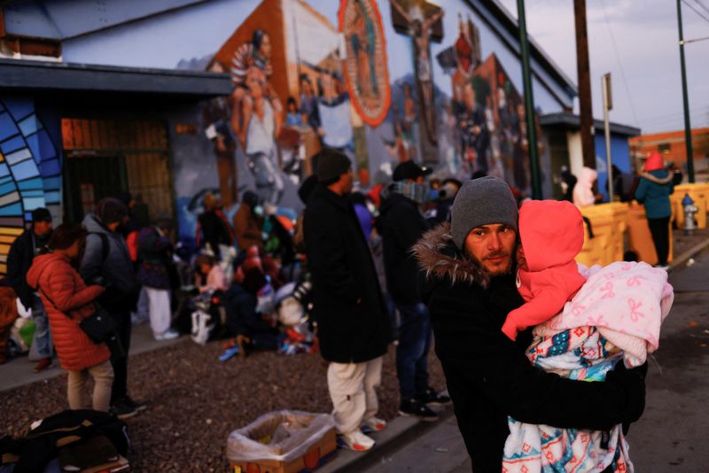 Daniel, un migrante de Venezuela, sostiene a su hija Yuri de 5 meses durante un día de bajas temperaturas, en el centro de El Paso, Texas, EEUU, el 23 de diciembre de 2022 (REUTERS/José Luis González)