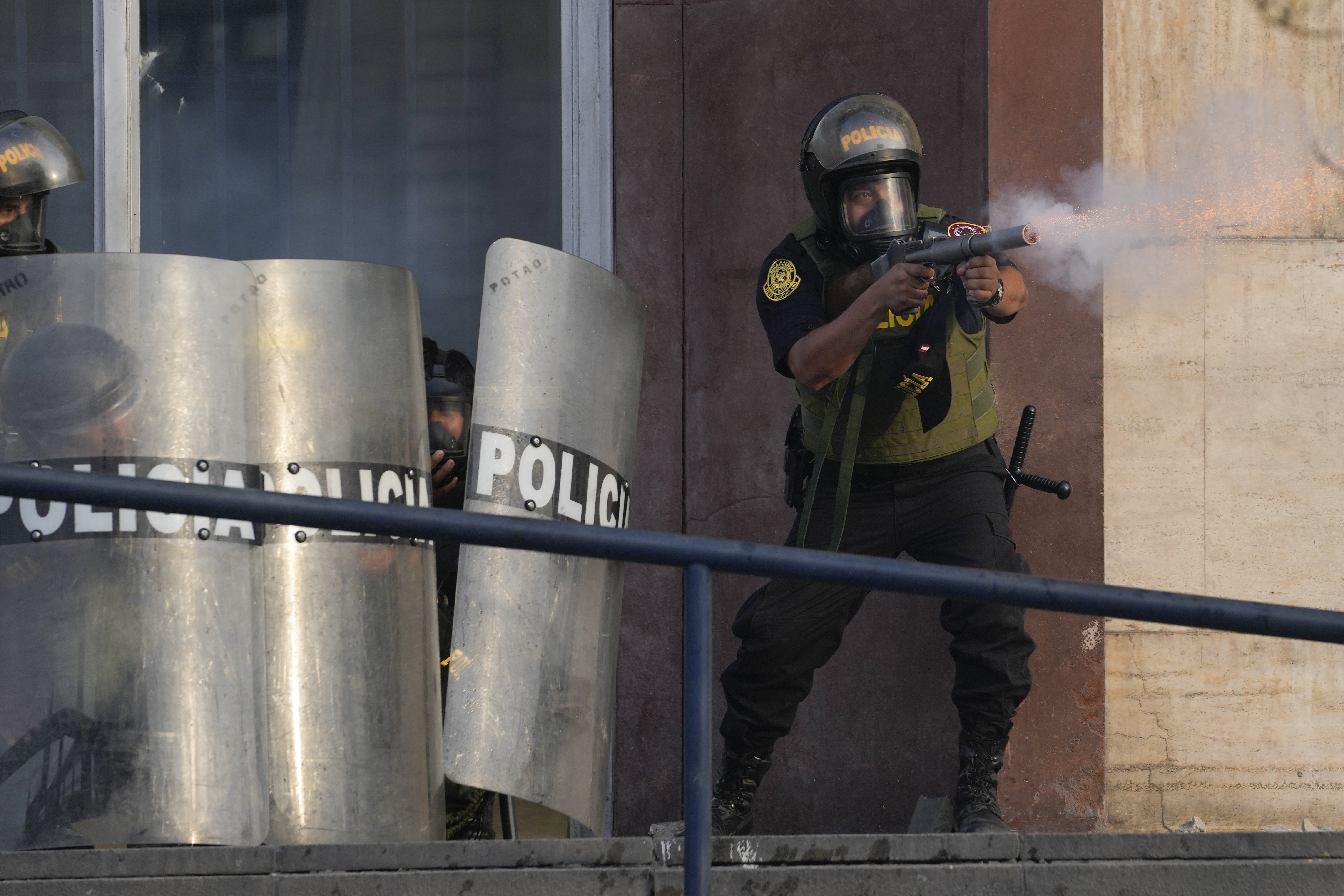 Un policía dispara gases lacrimógenos para dispersar a simpatizantes del destituido presidente Pedro Castillo, el lunes 12 de diciembre de 2022, en Lima. (AP Foto/Martin Mejia)