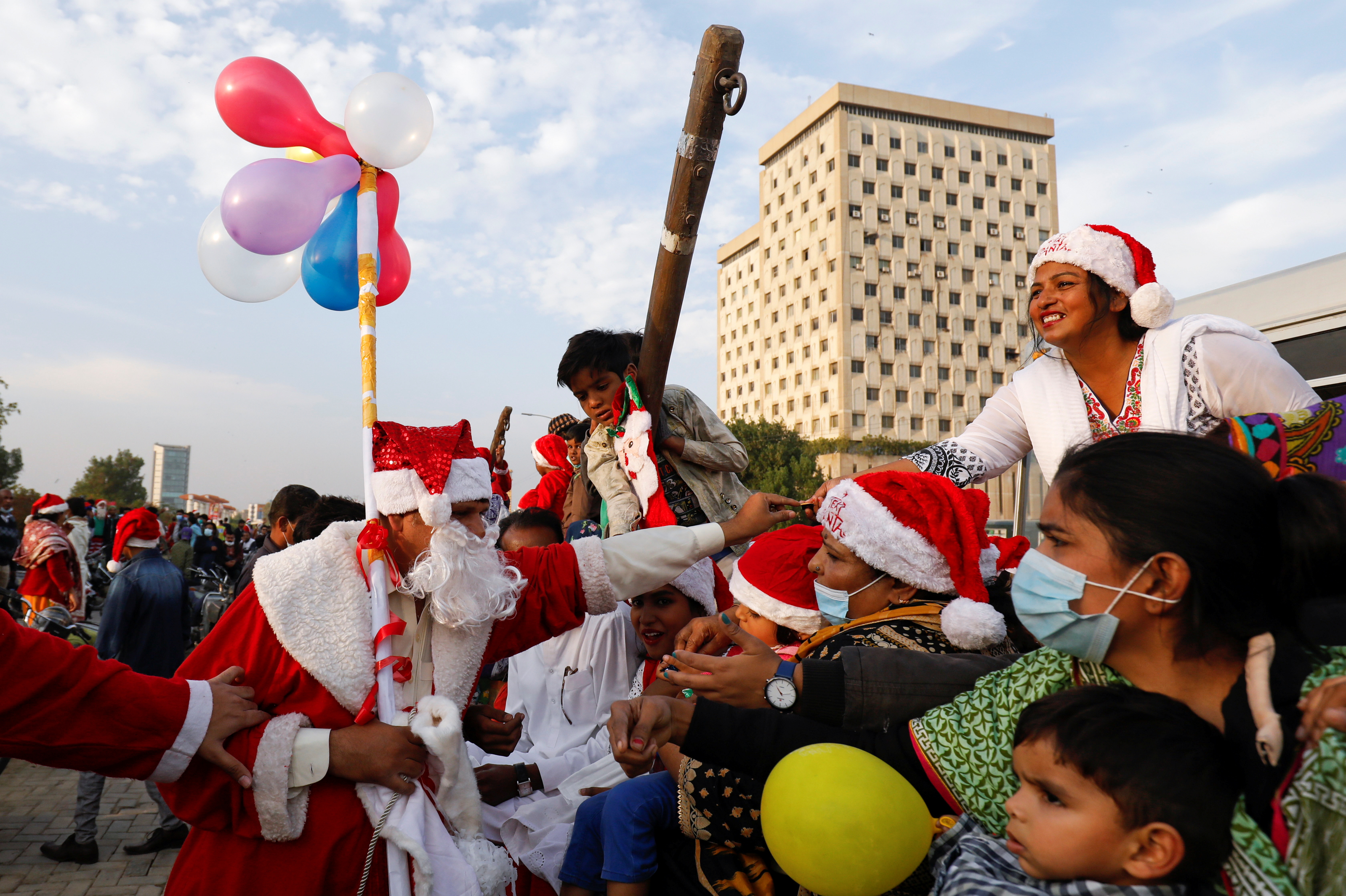 Un hombre vestido con el traje de Papá Noel distribuye dulces entre la gente durante una manifestación por la paz en Karachi, Pakistán (REUTERS/Akhtar Soomro)