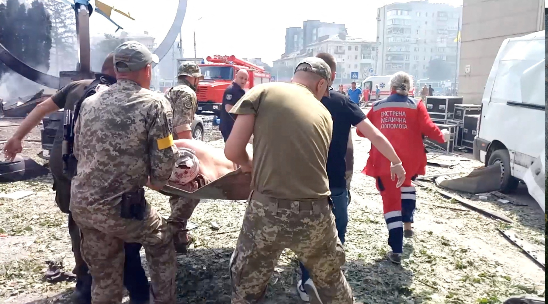 Rescatistas cargan el cuerpo de una persona en el lugar de un ataque militar ruso.