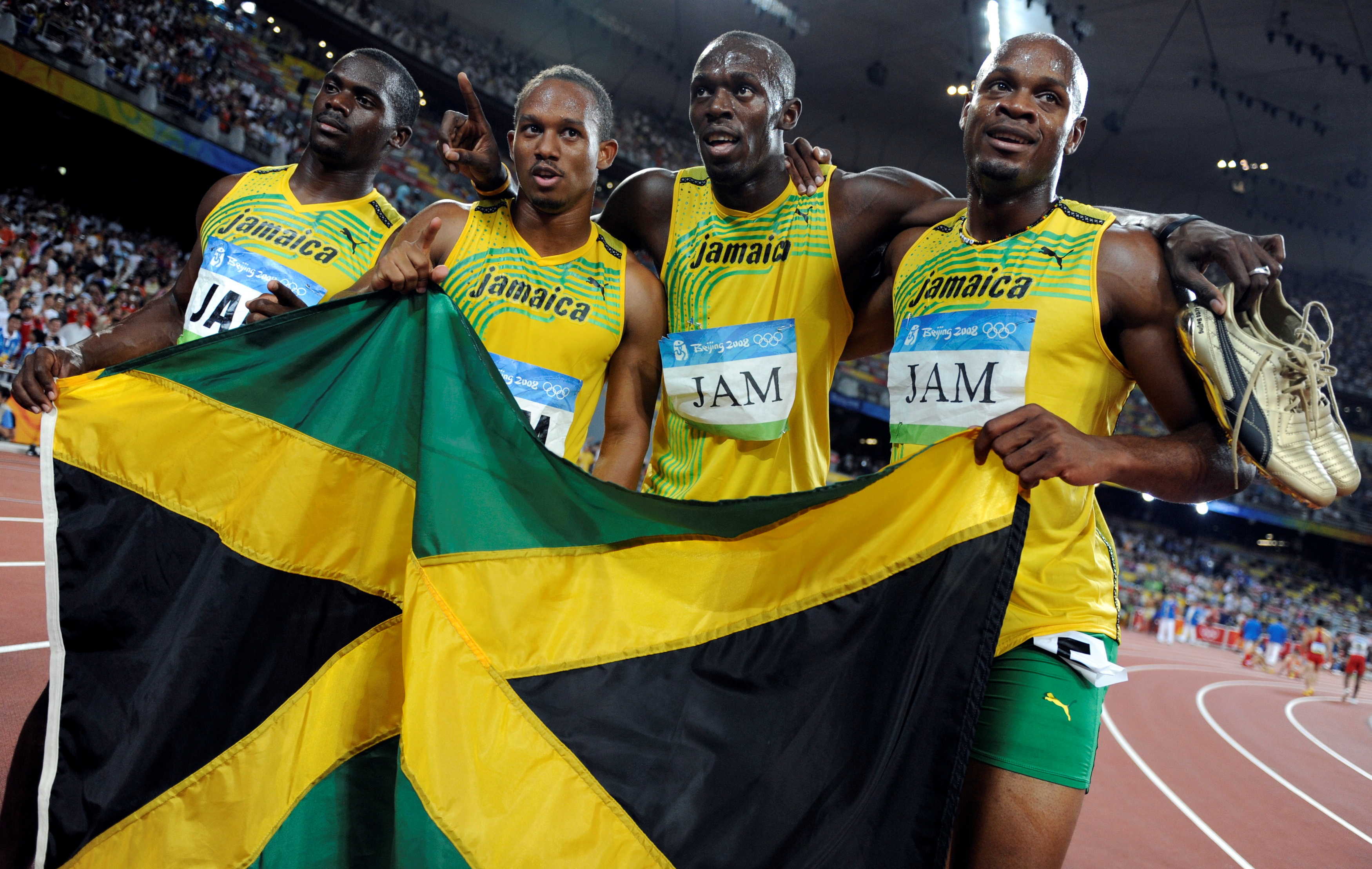 FILE PHOTO: Men's 4x100m relay Asafa Powell, Usain Bolt, Michael Frater, Nesta Carter of Jamaica celebrate after winning the final of the athletics competition in the National Stadium during the Beijing 2008 Olympic Games August 22, 2008.  Usain Bolt lost one of his nine Olympic gold medals after Jamaica team mate Nesta Carter was found guilty of doping at the 2008 Beijing Olympics.   REUTERS/Kai Pfaffenbach/File Photo