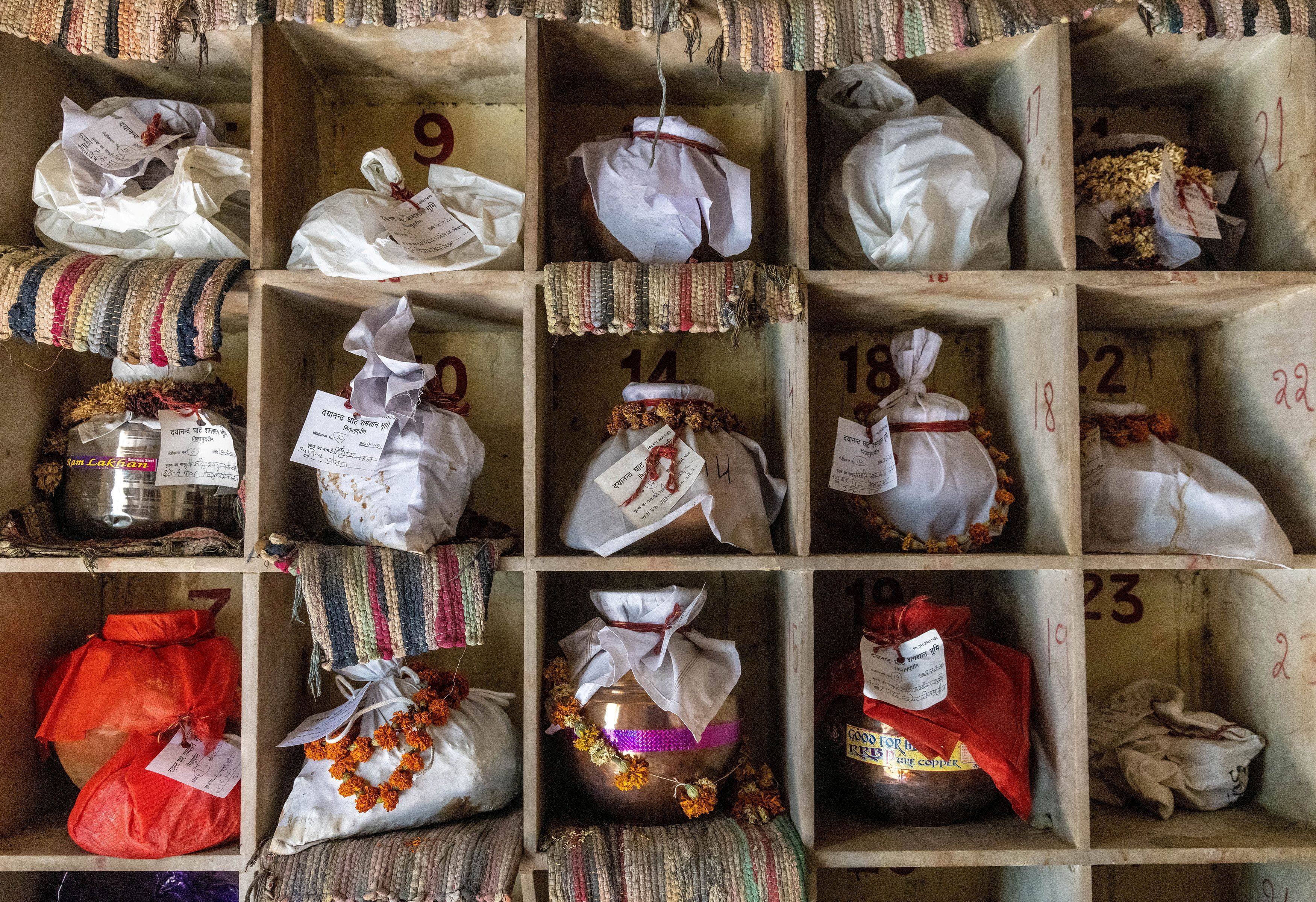 Las urnas que contienen las cenizas después de los ritos finales de las personas, incluidas las que murieron por complicaciones relacionadas con el coronavirus esperan la inmersión debido al cierre, en un crematorio en Nueva Delhi, India, 6 de mayo de 2021. 