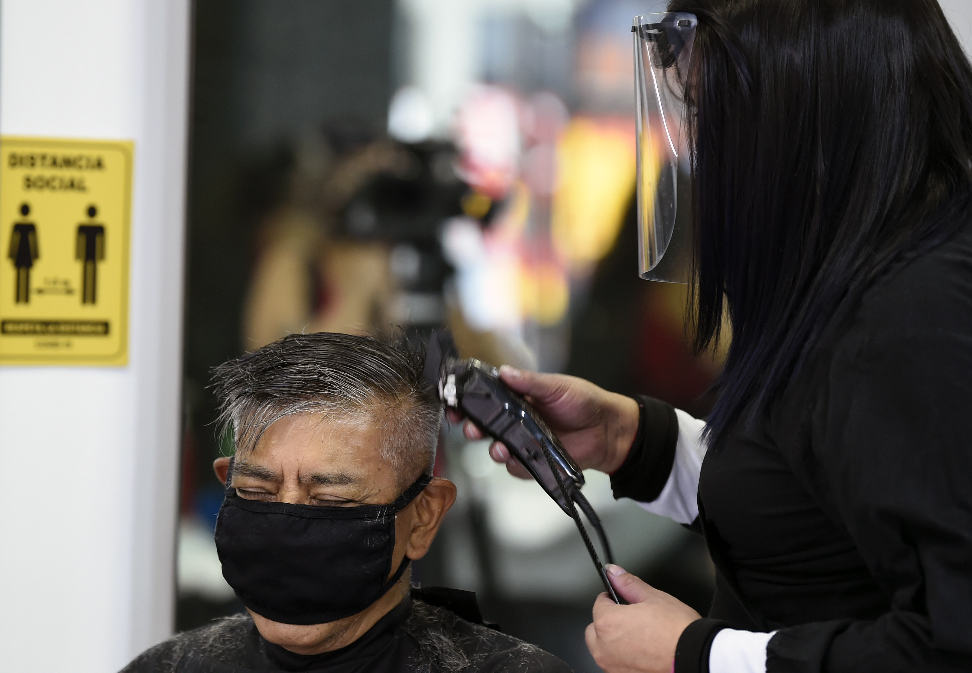 Un cliente se corta el pelo en un salón de belleza, durante la pandemia COVID-19, en la Ciudad de México el 29 de junio de 2020. (Foto: ALFREDO ESTRELLA / AFP)