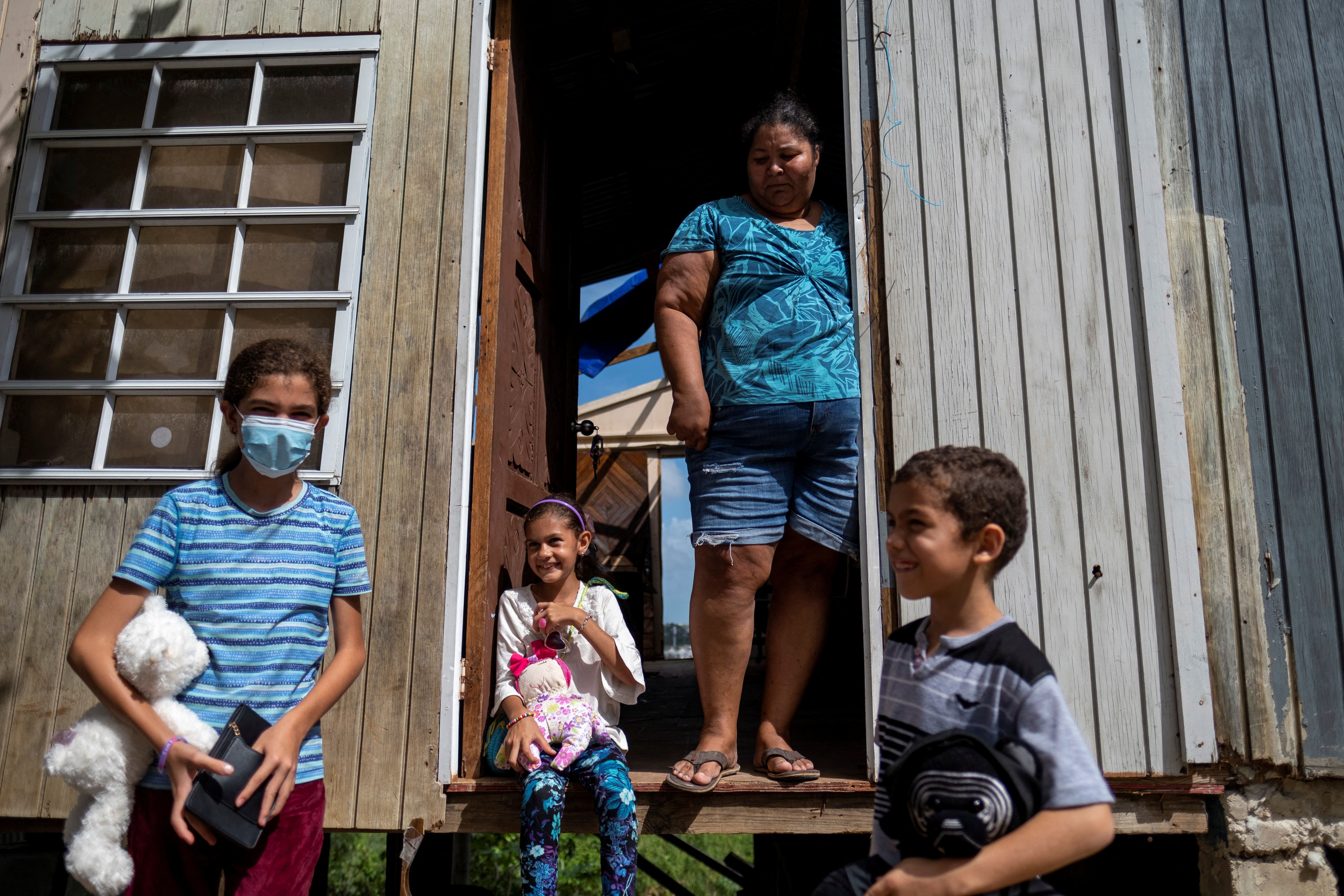 Una familia se para frente a su hogar dañado después del huracán Fiona en Ponce. REUTERS/Ricardo Arduengo
