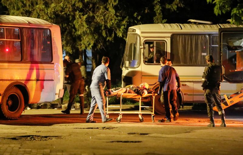 Un herido de las fuerzas ucranianas de la asediada fábrica de acero Azovstal en Mariúpol es transportado en una camilla fuera de un autobús (REUTERS/Alexander Ermochenko)