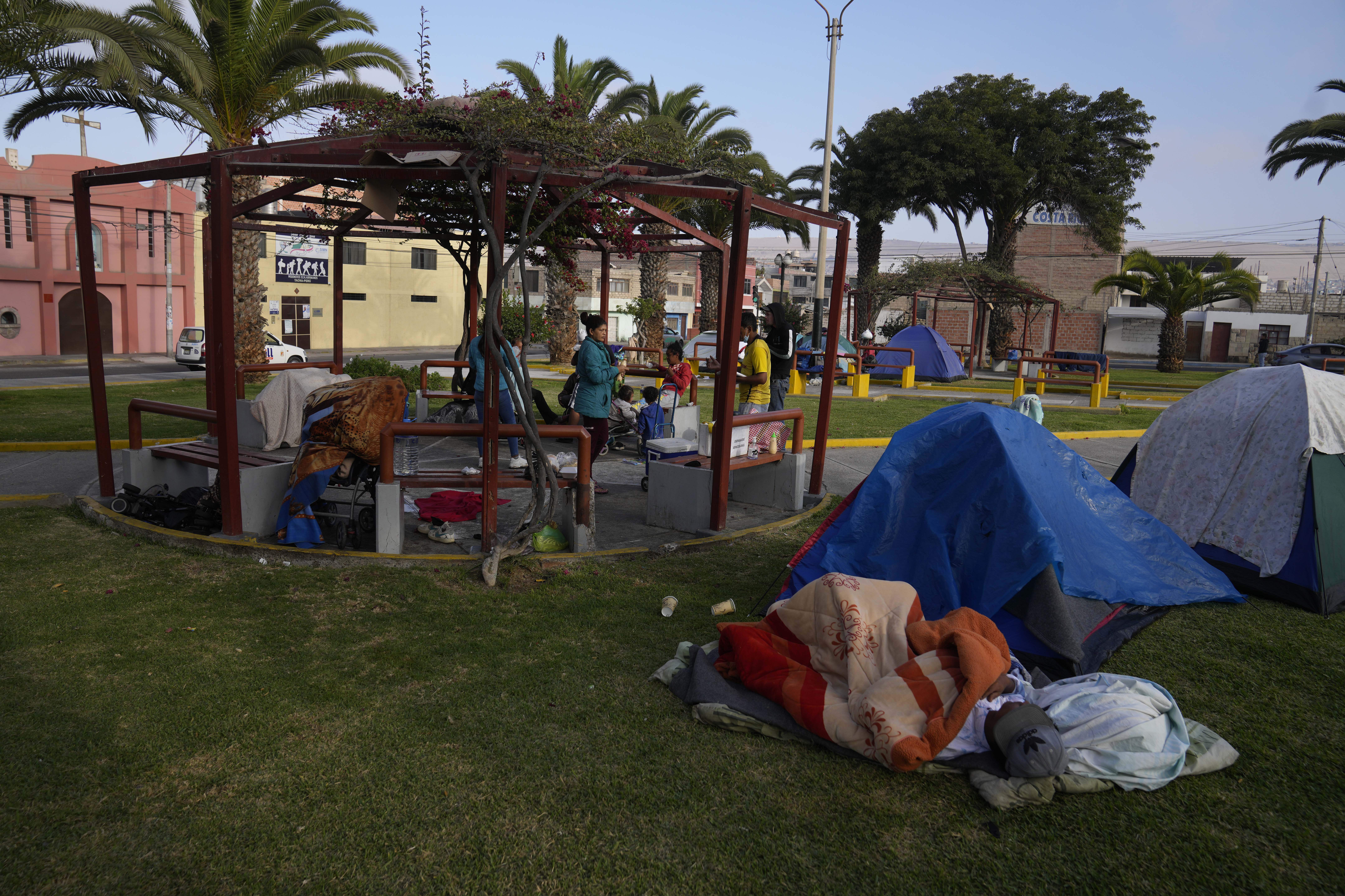 Migrantes venezolanos acampan en un parque en Tacna, Perú, el sábado 29 de abril de 2023 (Foto AP/Martín Mejía)