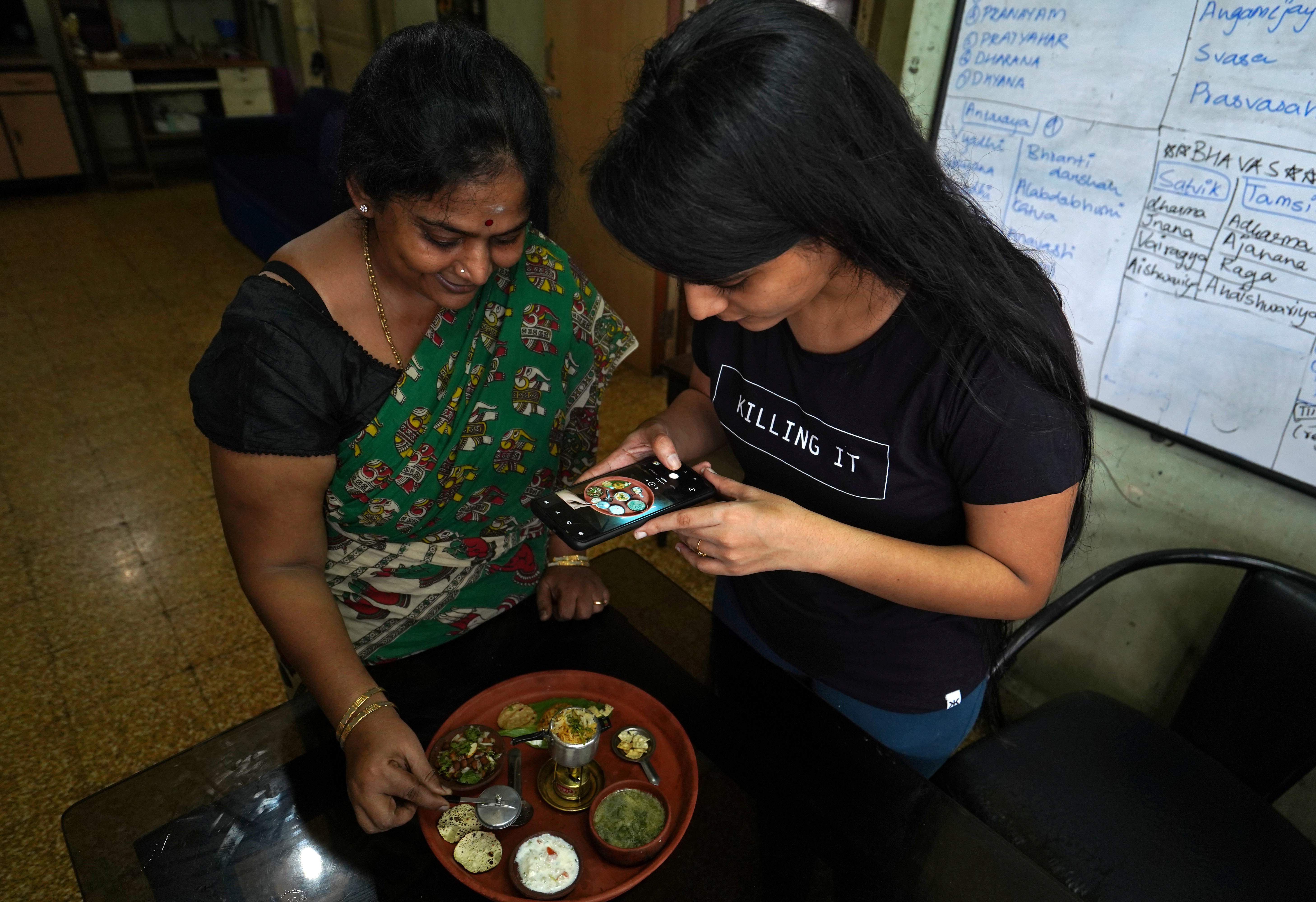 Geetha Sridha, de 54 años, que solía postear varios videos por día en TikTok, graba mientras cocina con su hija. Según afirma, comenzará a publicar en otra app (Reuters)