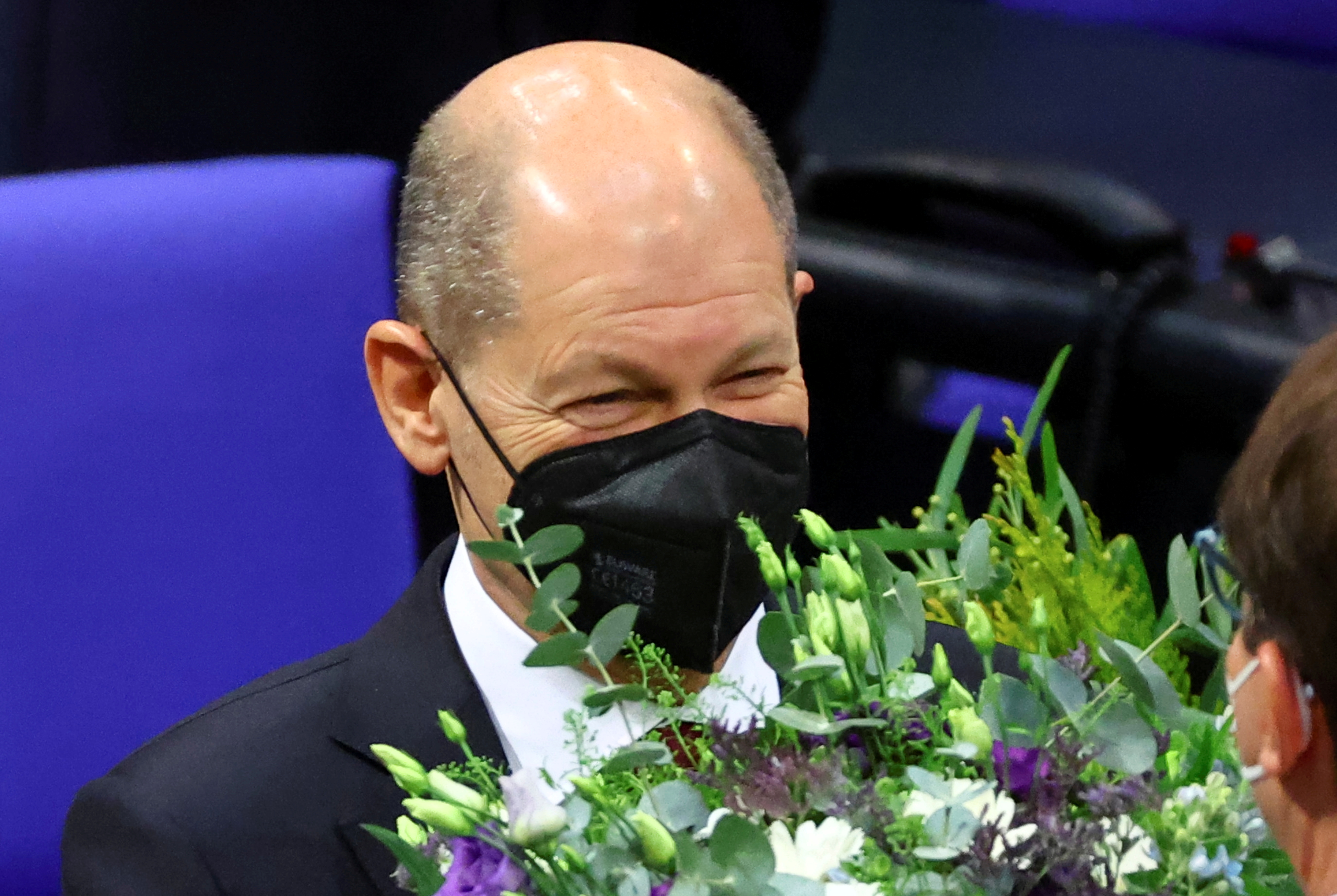 Scholz recibe flores tras la sesión del Parlamento alemán que lo eligió canciller. (REUTERS/Fabrizio Bensch)